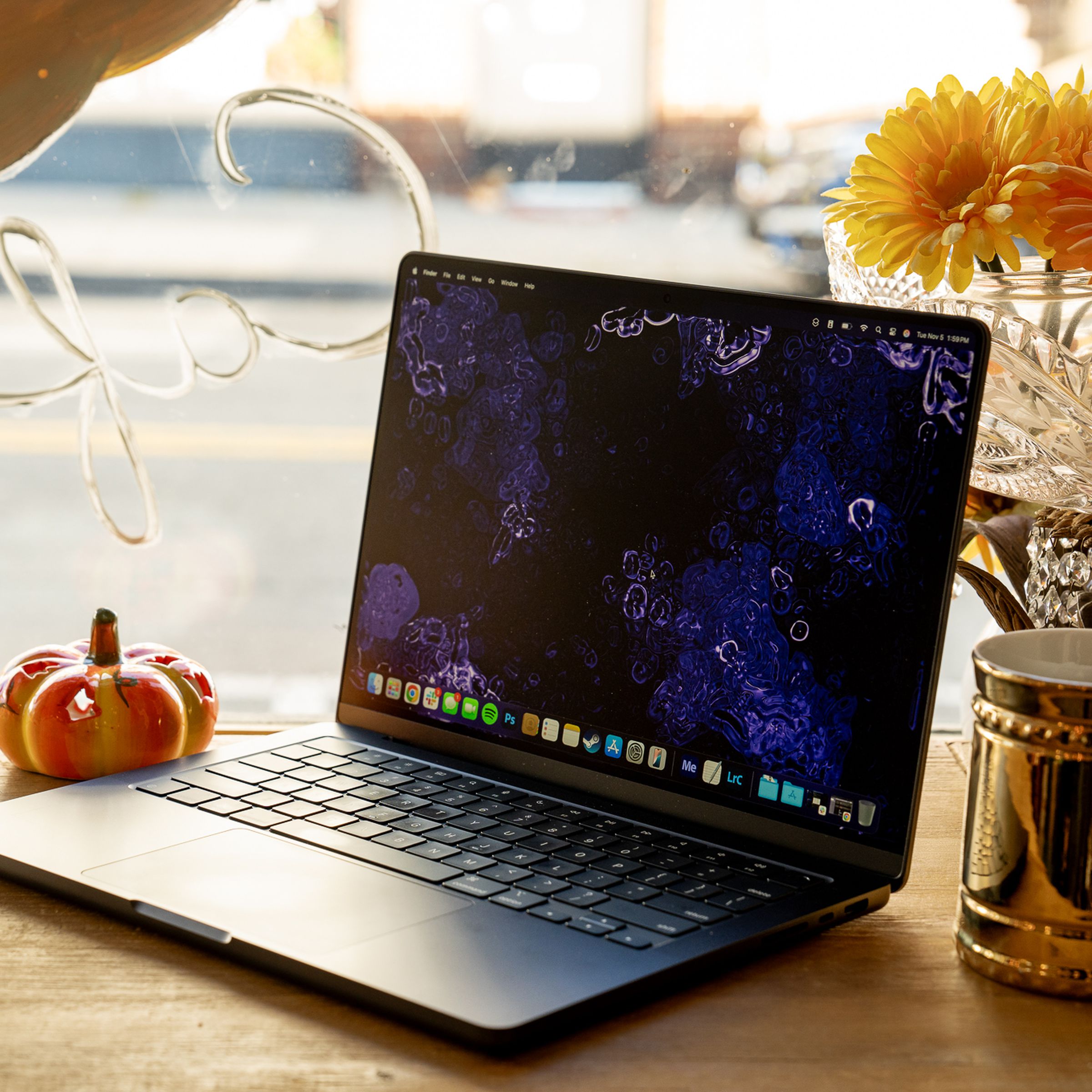 A 14-inch MacBook Pro M4 laptop on a wooden cafe counter near a window.