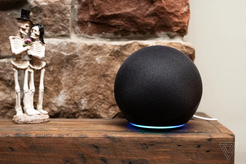 A black Echo smart speaker on a mantlepiece.