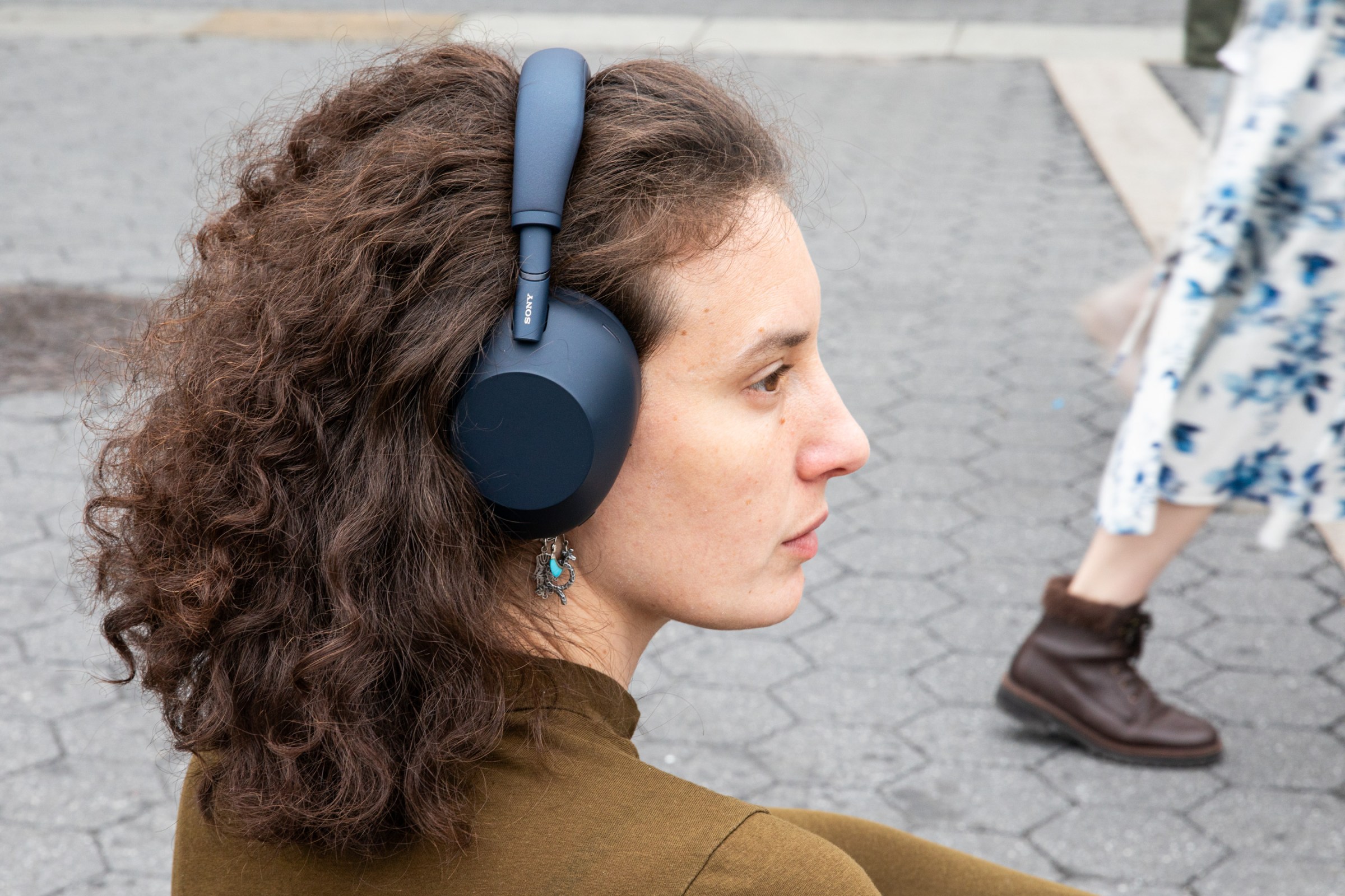 Woman with long curly hair wearing a set of over-the-ear headphones.