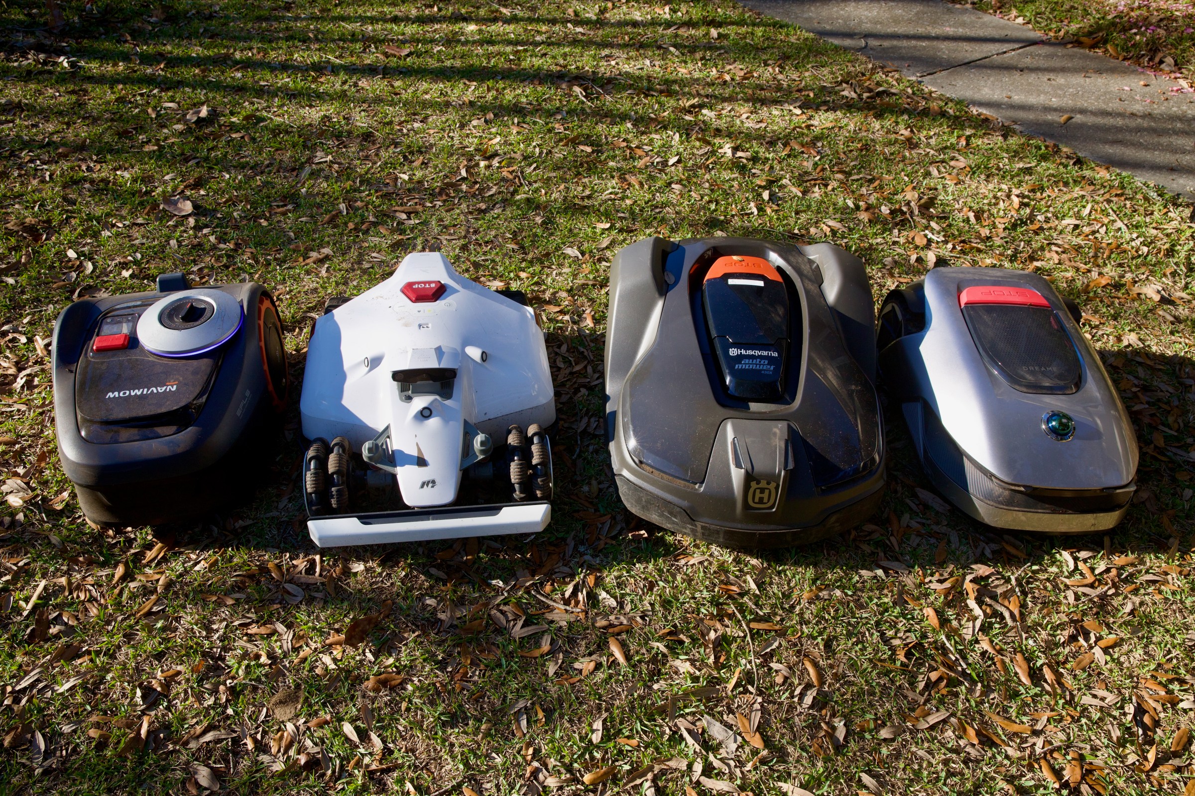The lineup, left to right: Segway Navimow i110N, Mammotion Luba 2, Husqvarna 430X, Dreame A1