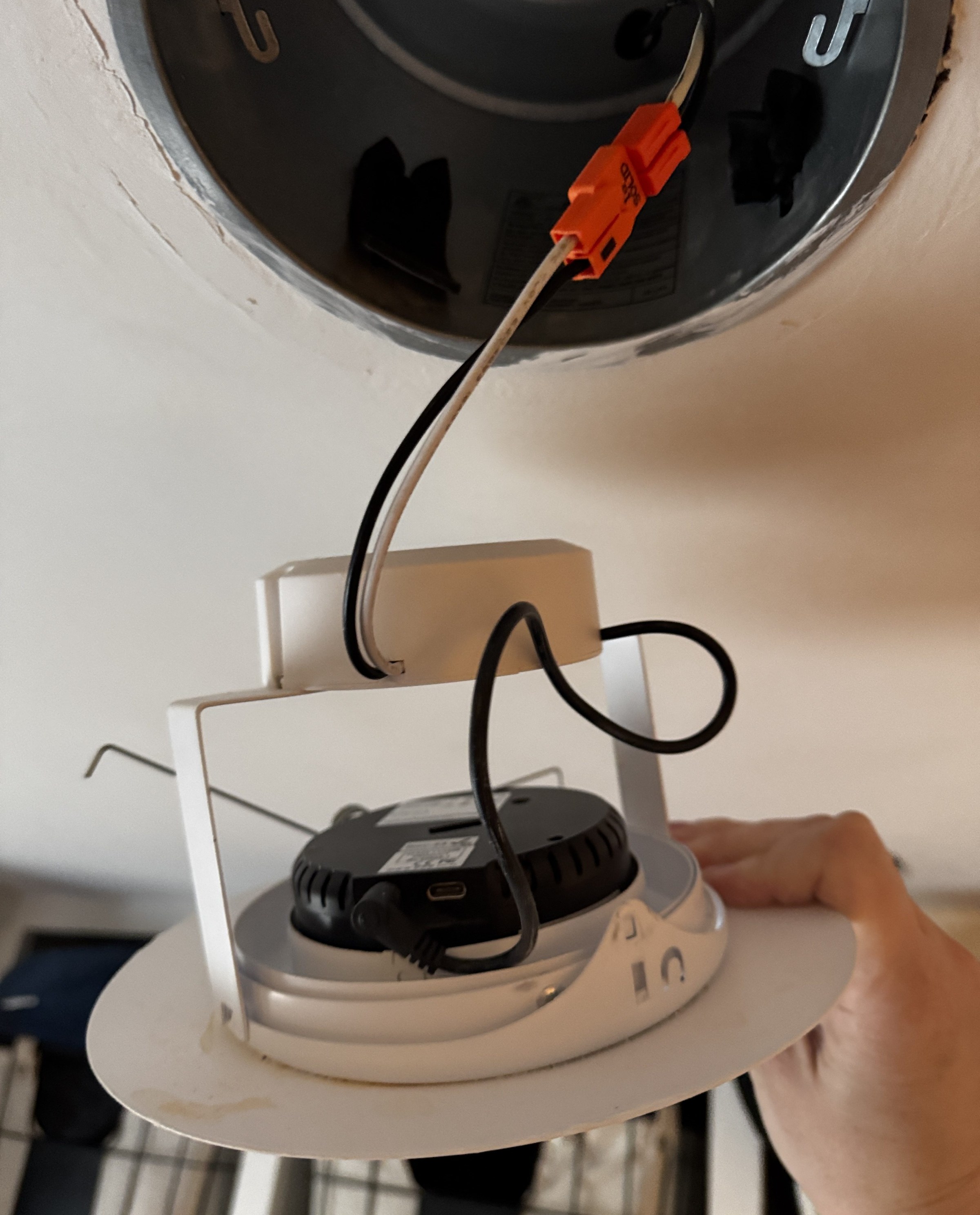 The transmitter fits into the Wi-Charge ceiling light fixture and connects to power via a standard barrel plug.