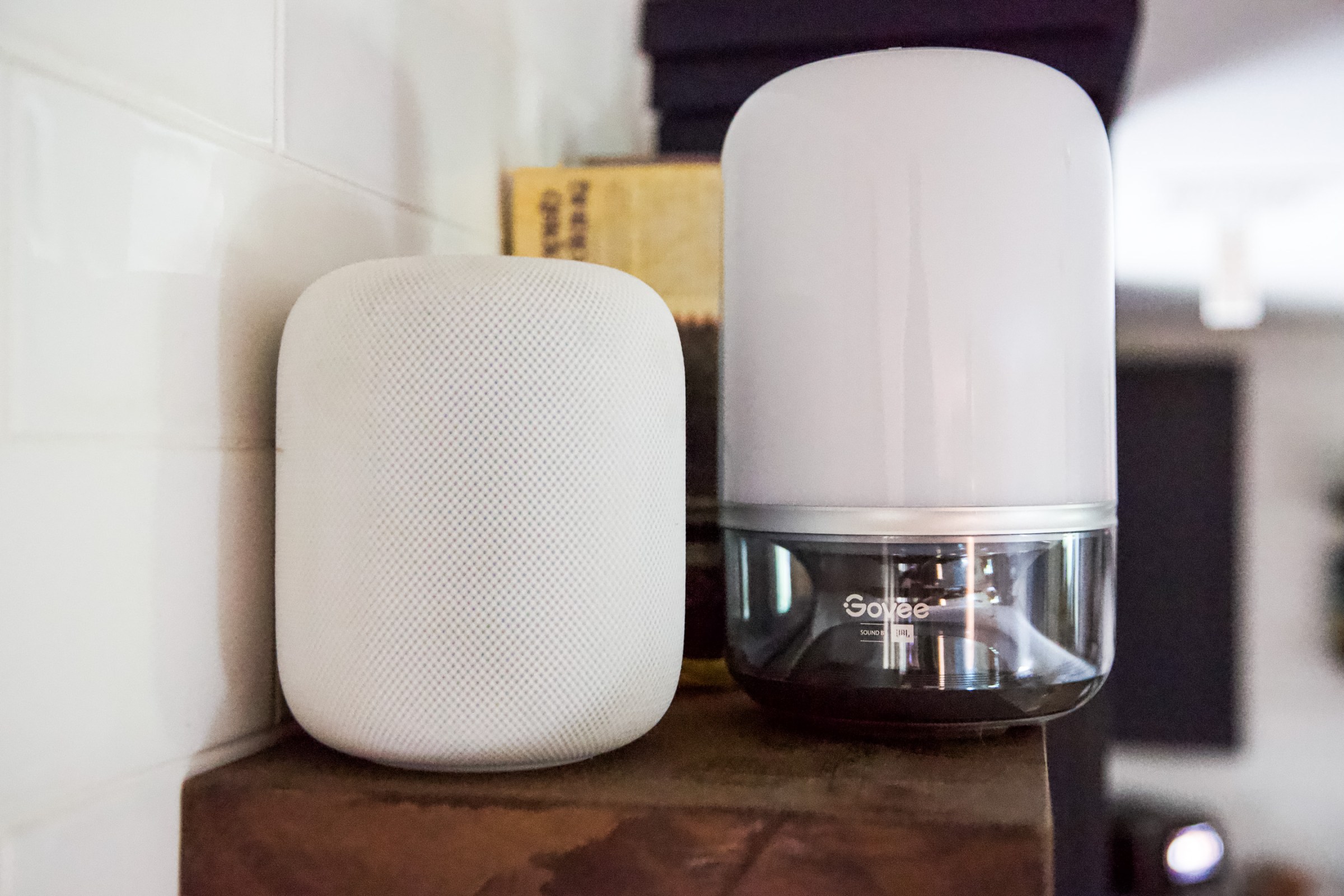 The Govee Table Lamp is a similar size and shape to Apple’s HomePod smart speaker (left), but it has a smaller speaker grille and its main body is a plastic lamp.