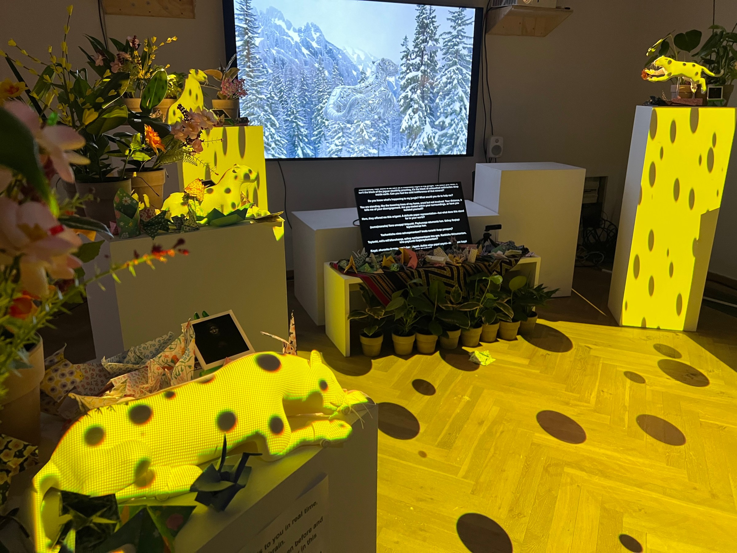 A screen showing a digital Huk surrounded by smaller Huk statues on platforms. They’re all lit up in yellow polka dotted light.