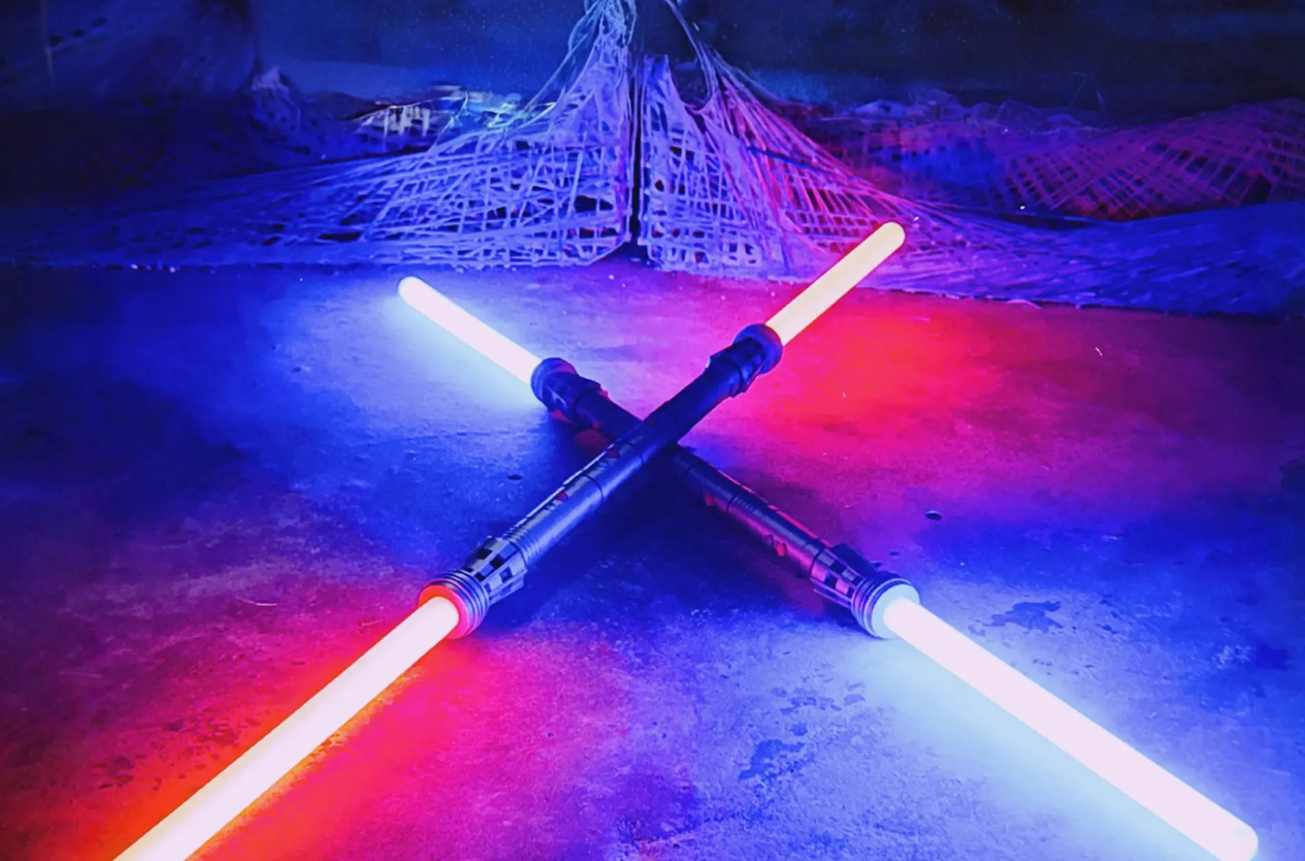 Two lightsabers on a purple and blue background