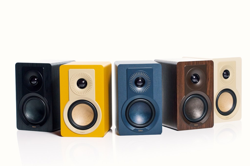 Pictures shows all five colours of the Dali Kupid speaker – black, yellow, blue, brown and off-white – arranged in a crescent shape. 