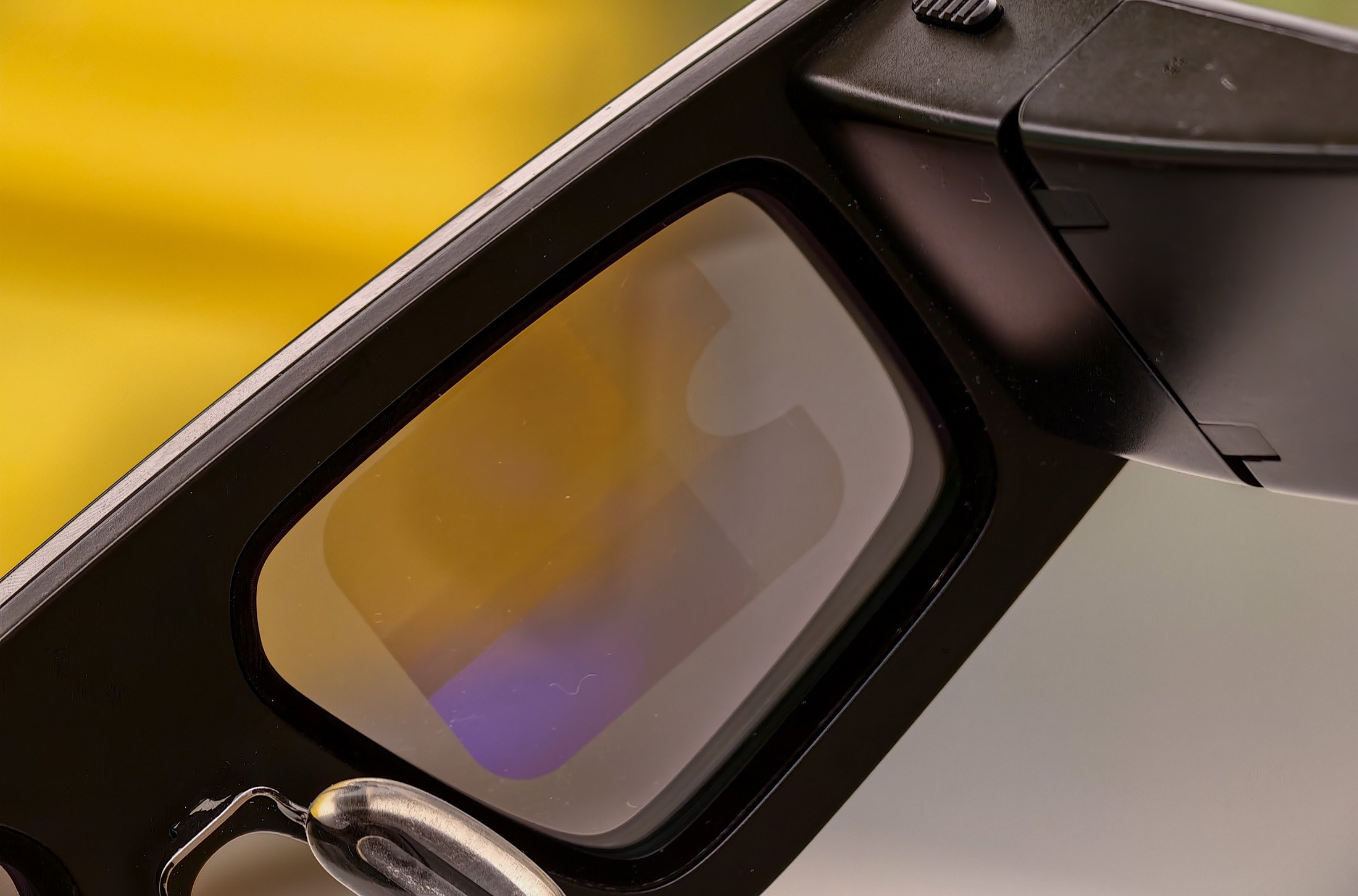Snap Spectacles on a yellow table, showing the display on the lens