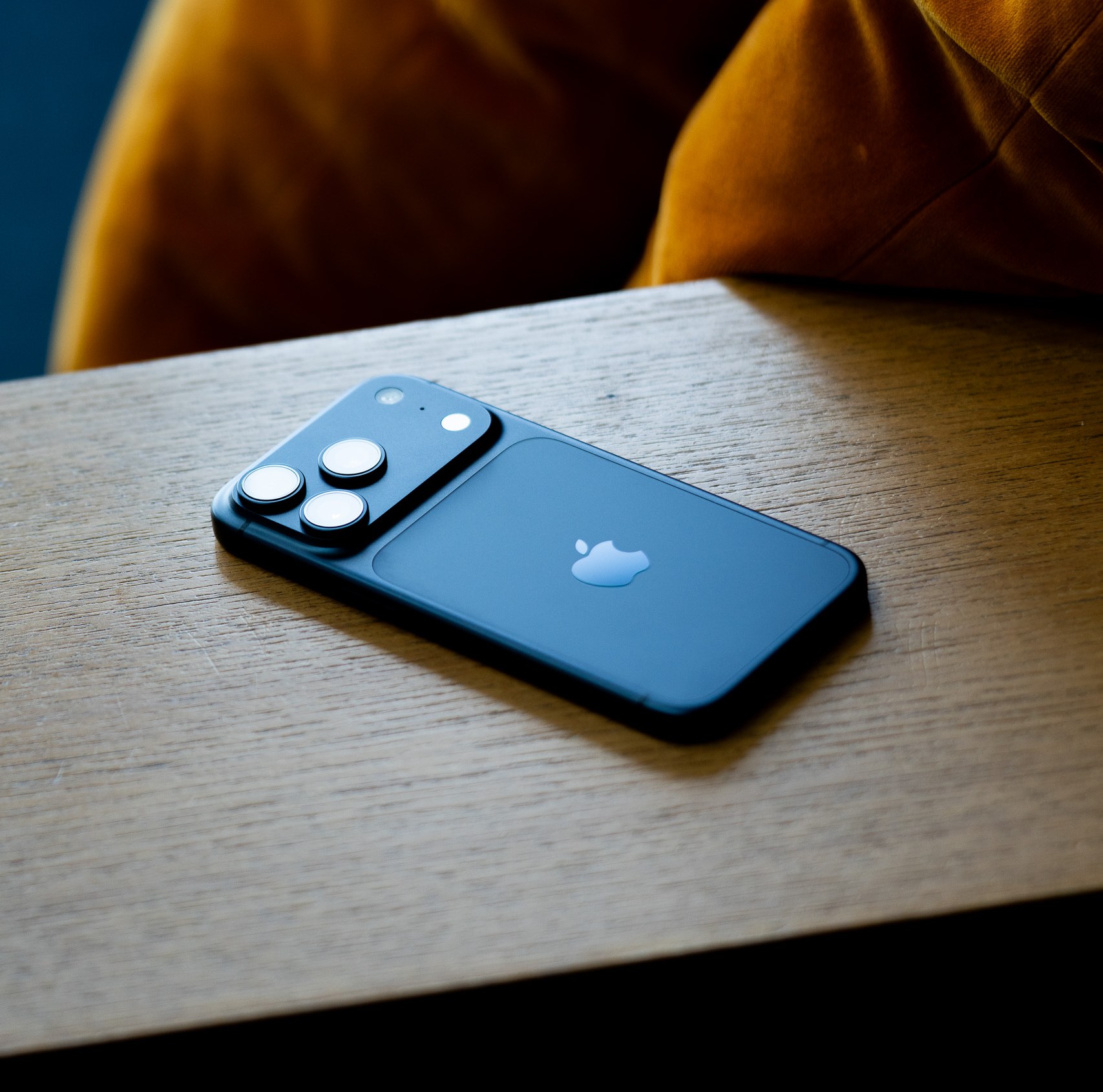 A navy blue iPhone on a wooden background
