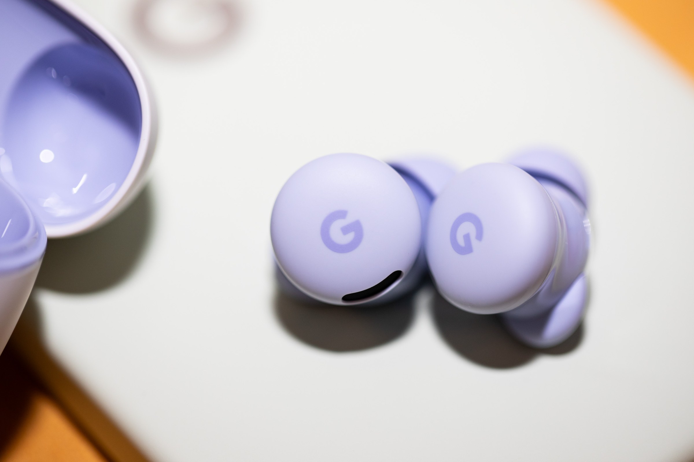 A photo of two small people earbuds on a table.