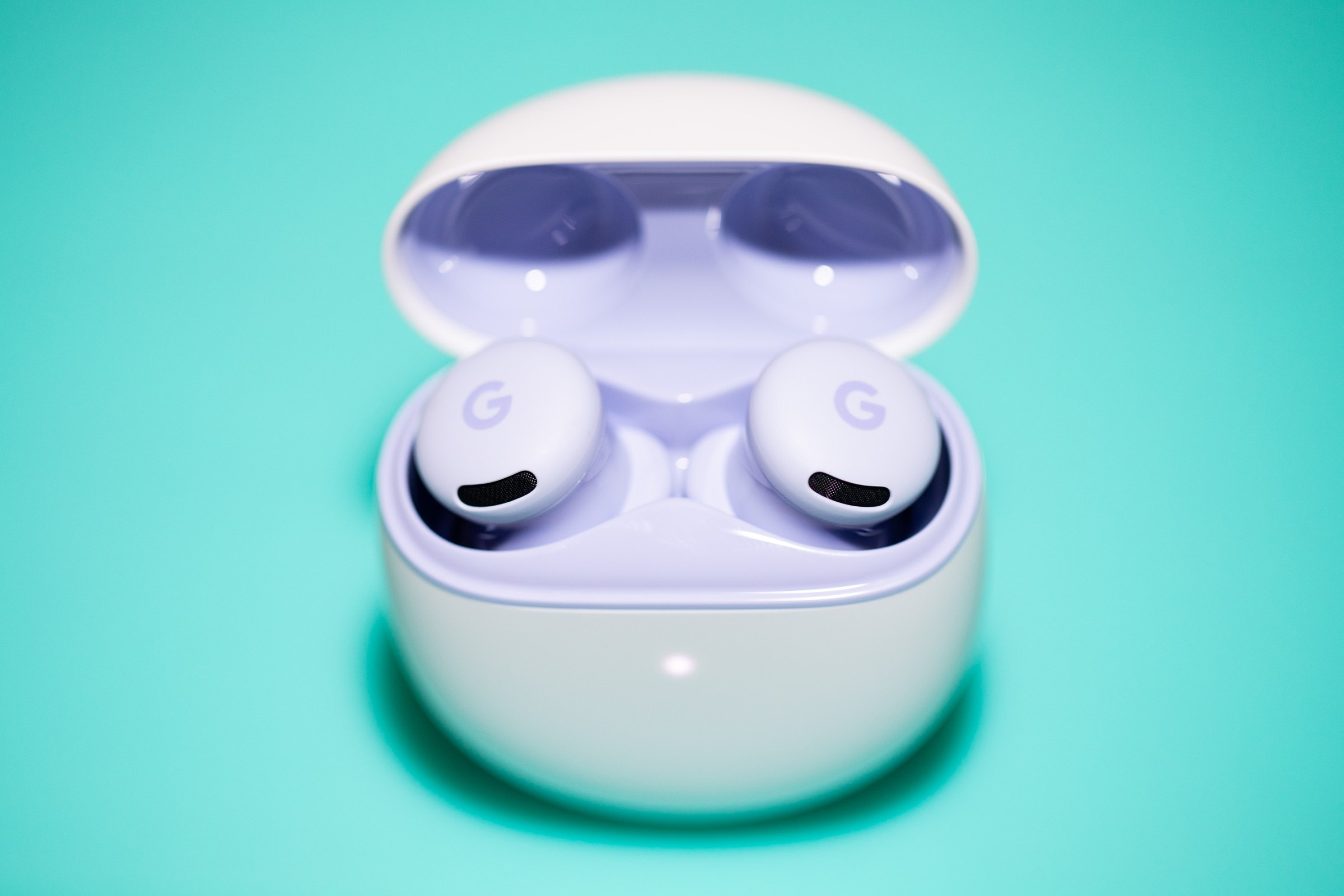 A photo of the Pixel Buds 2A on a green background.