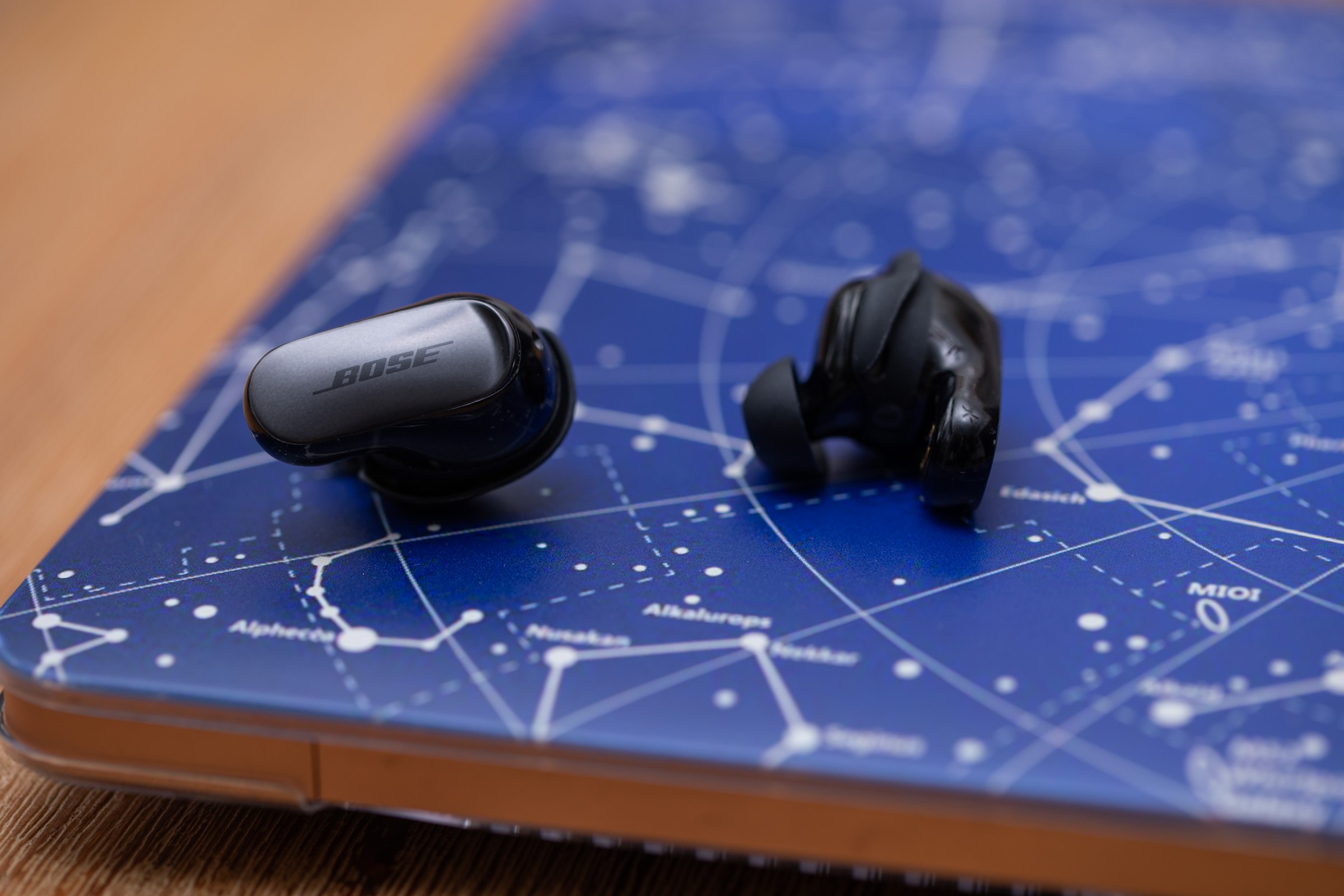 The Bose Ultra Earbuds Gen 2 on a laptop with a blue constellation cover.