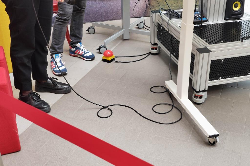 A large red foot button on the floor