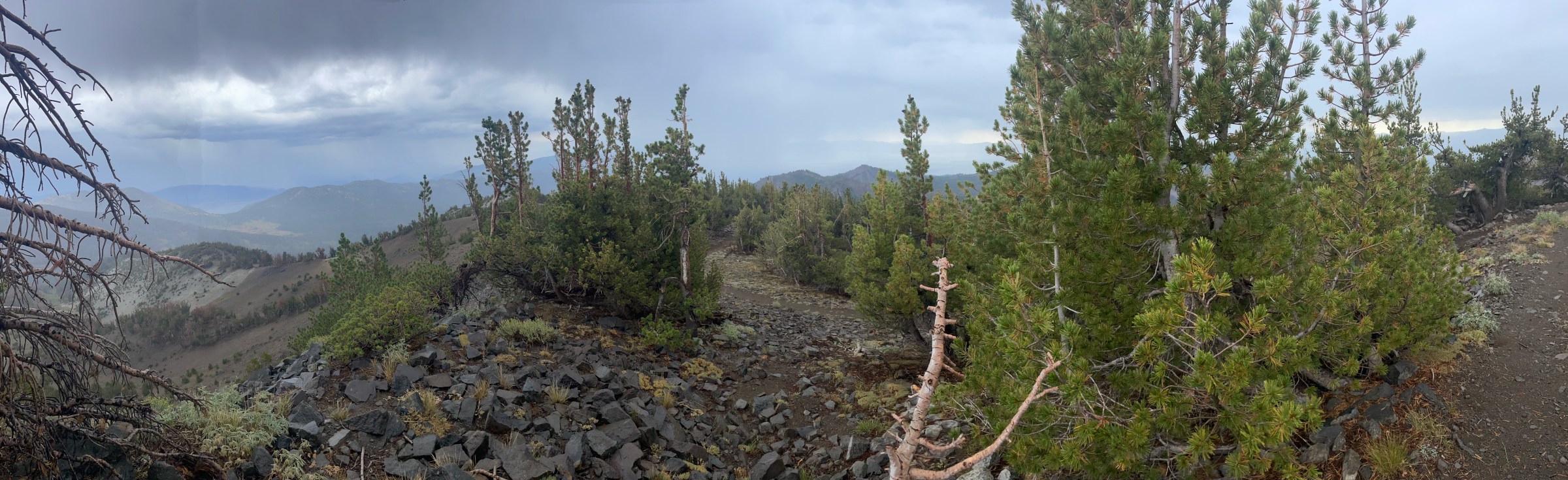 A panoramic view of an overcast sky from a mountain top.