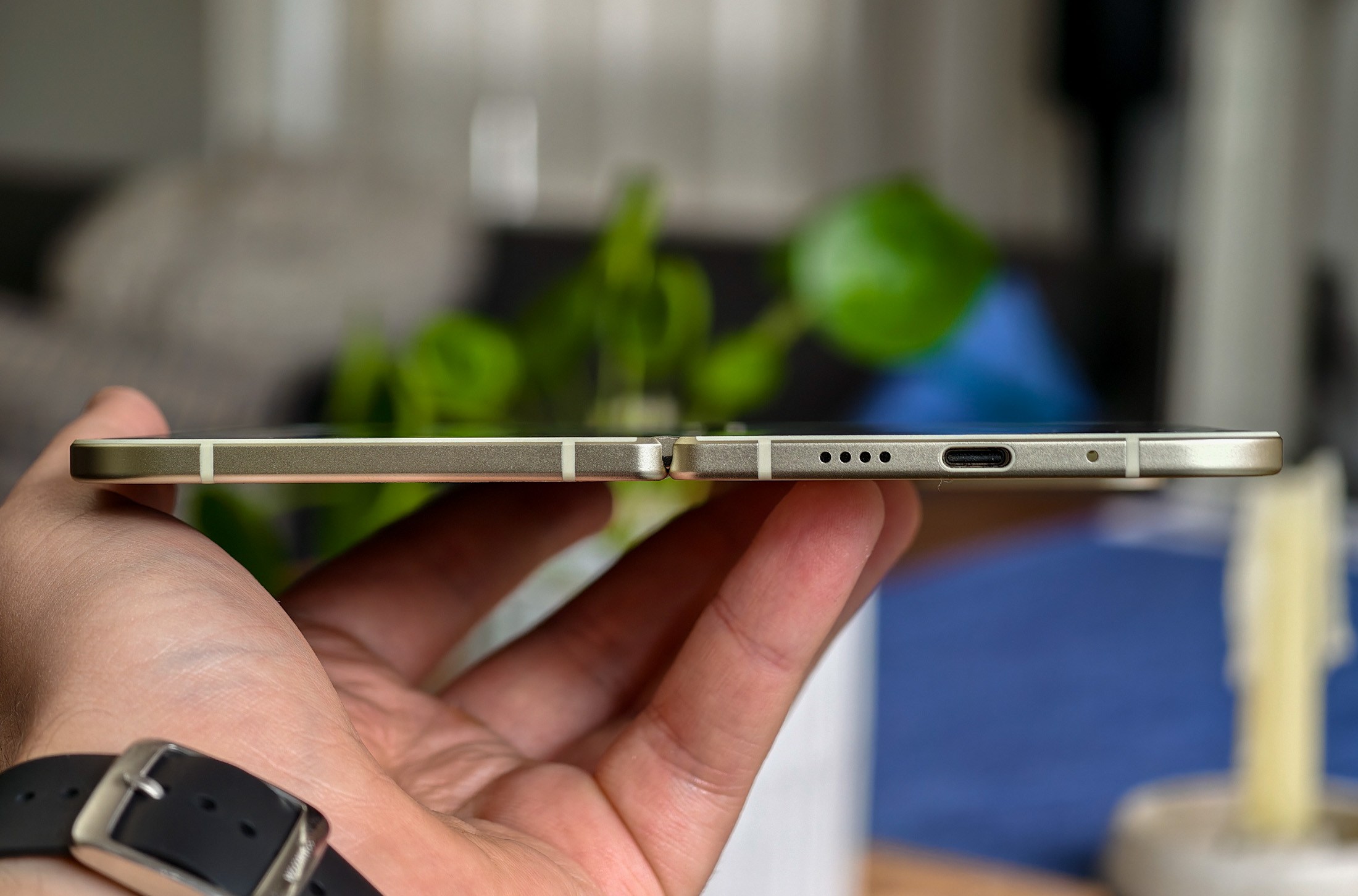 Google Pixel 10 Pro Fold held in a hand, horizontal and open, showing the phone’s thin edge