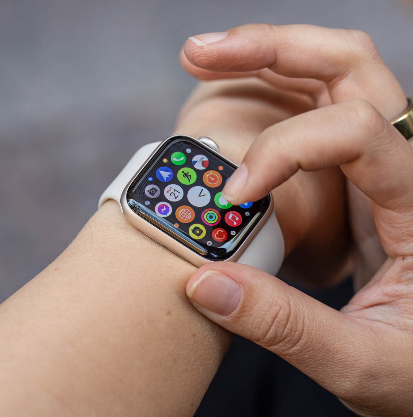 Woman looking at the app grid on the Apple Watch SE (2022).