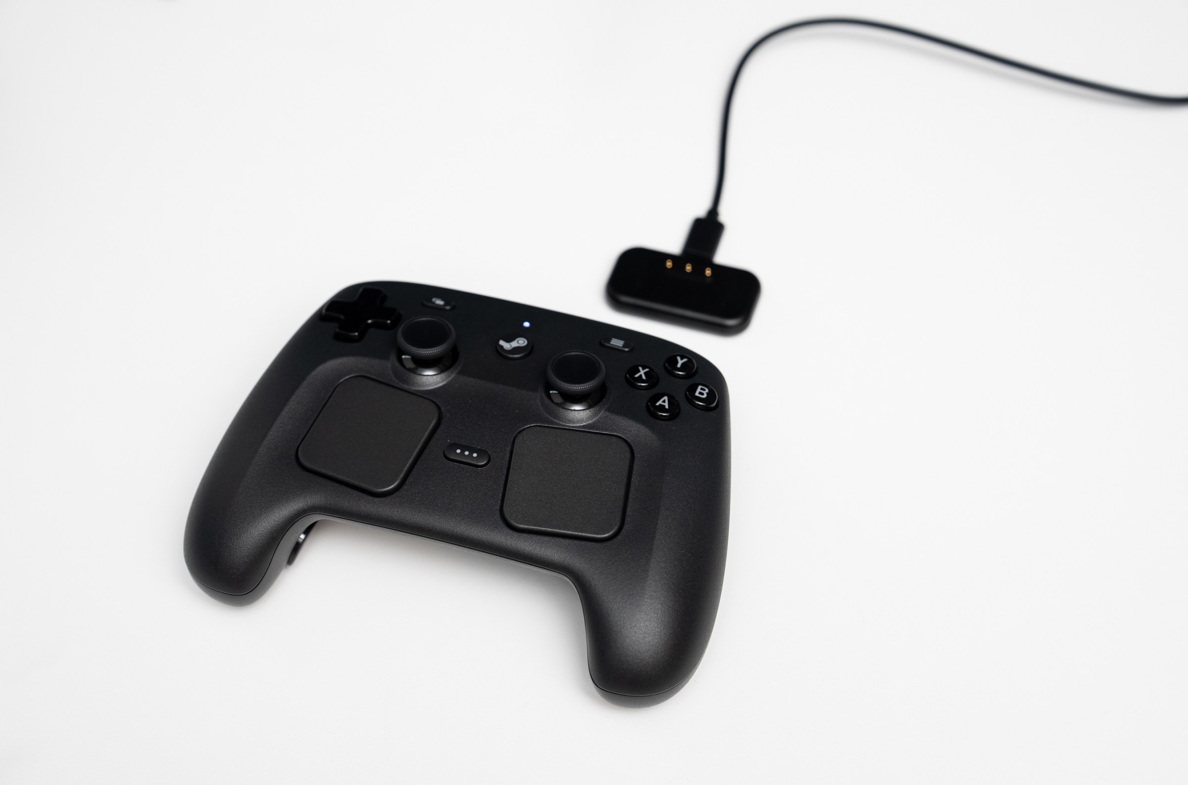 The puck serves double duty: It gives the controller a low-latency, 8ms end-to-end connection to a computer, and charges the controller using pogo pins.