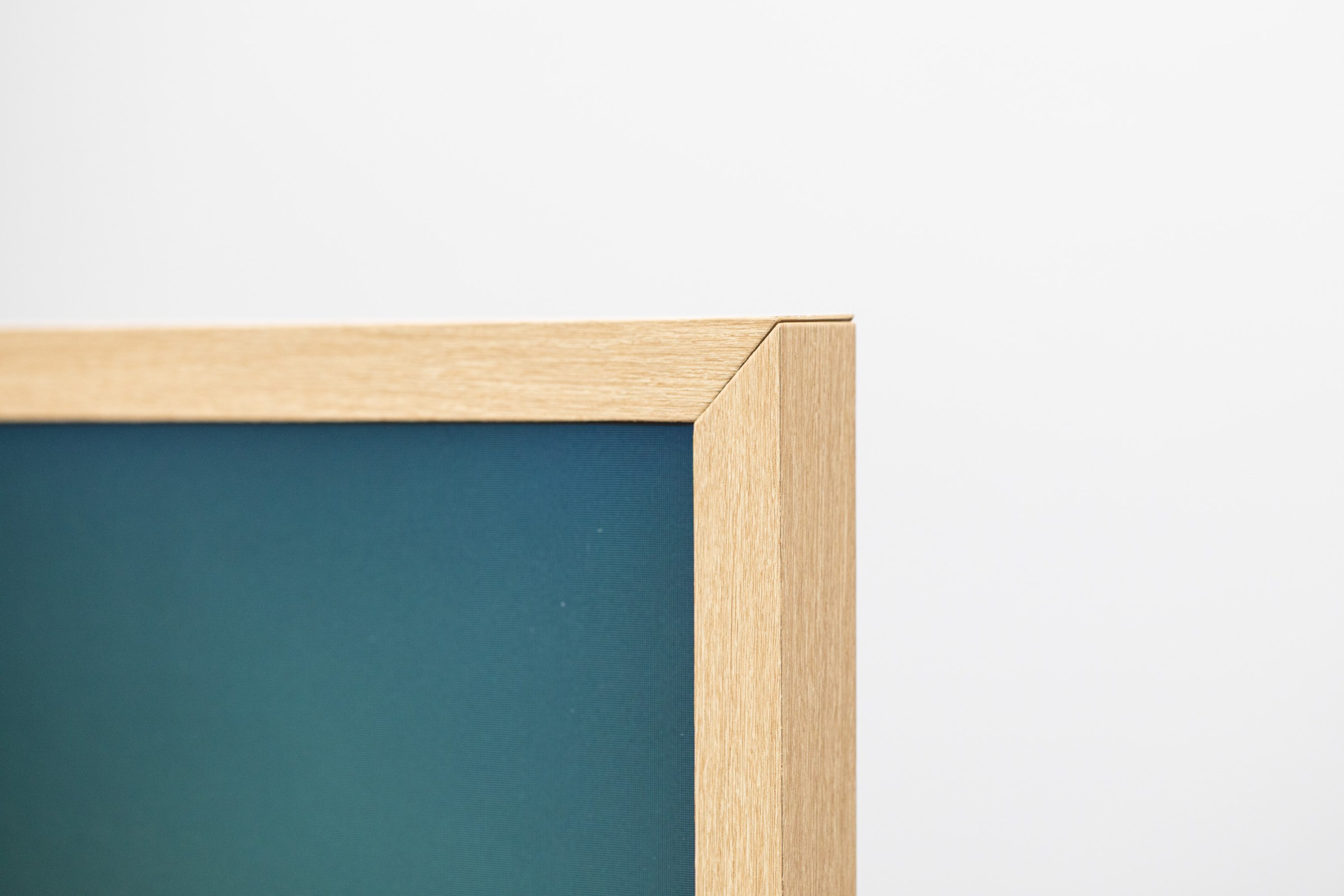 The top right corner of The Frame Pro TV with a light brown frame.