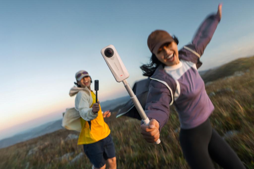 Two people holding selfie sticks with Insta360 X4 Air action cams attached