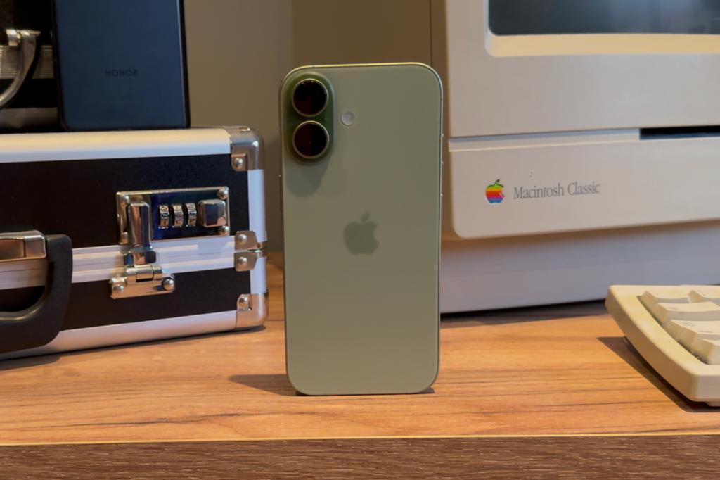 iPhone 17 sat on desk in front of retro tech devices