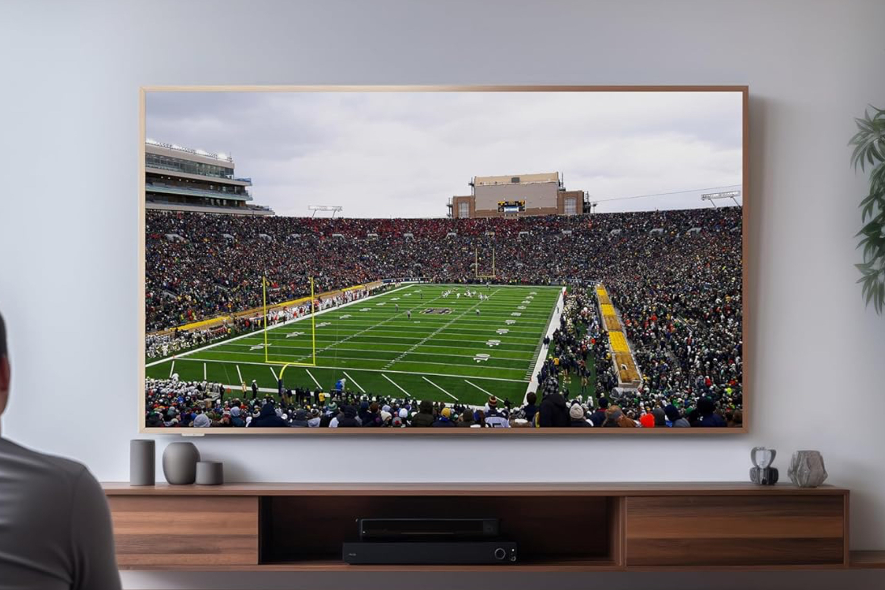 TCL's A300W 4K TV mounted onto a wall above an entertainment center.