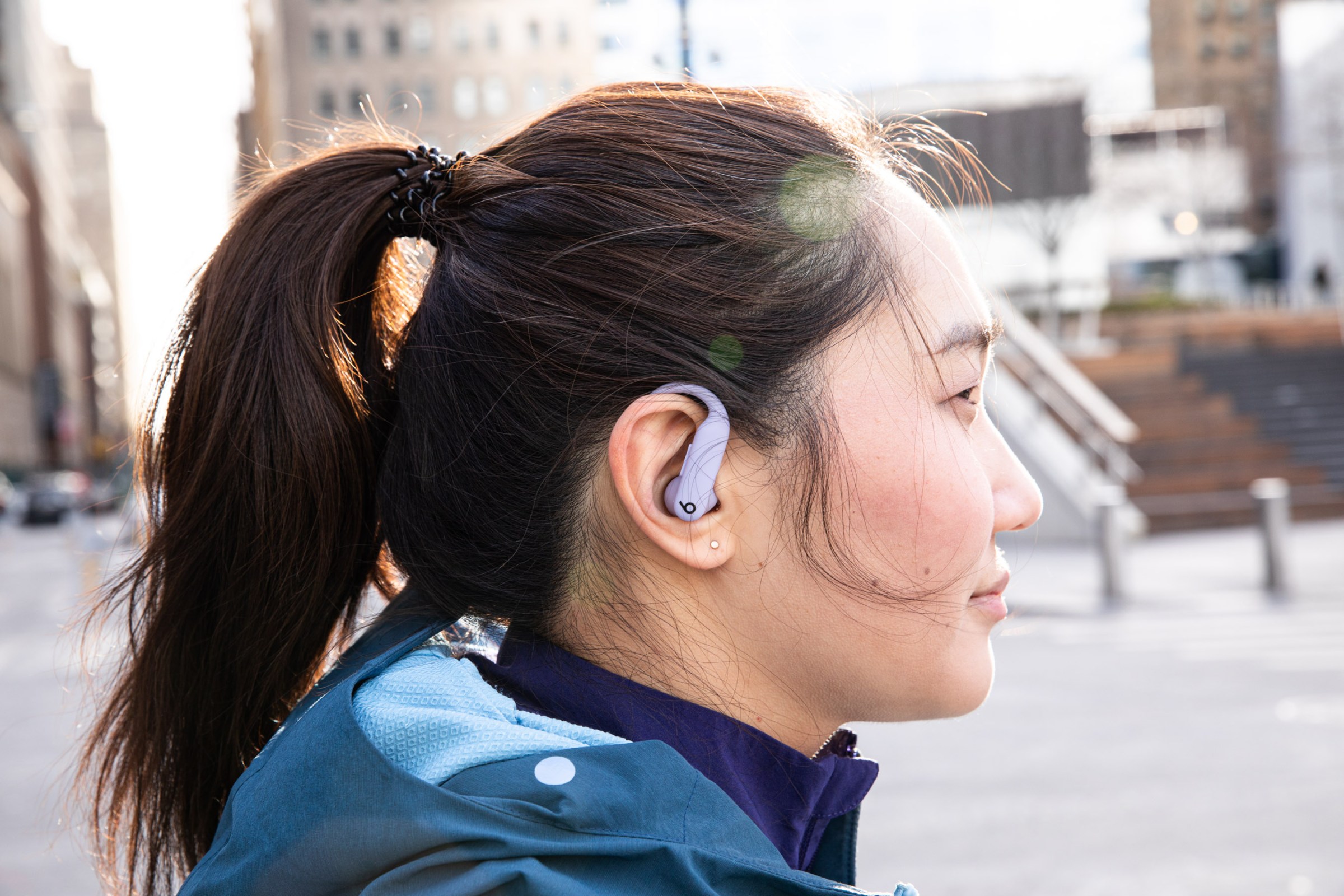 A photo of a person wearing the Powerbeats Pro 2 earbuds.