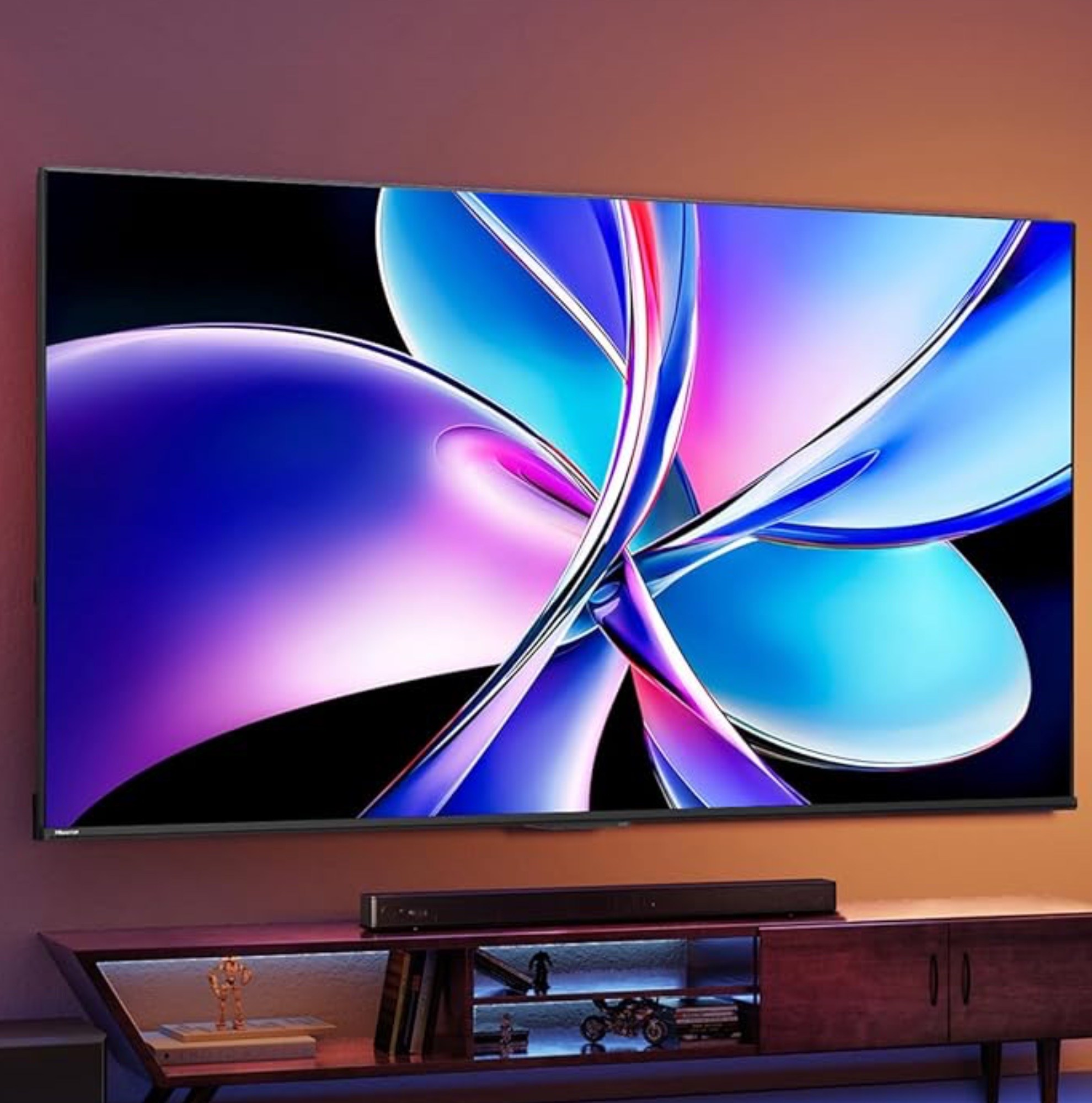 Hisense’s QD7 4K TV mounted onto a wall above a sound bar and media center.