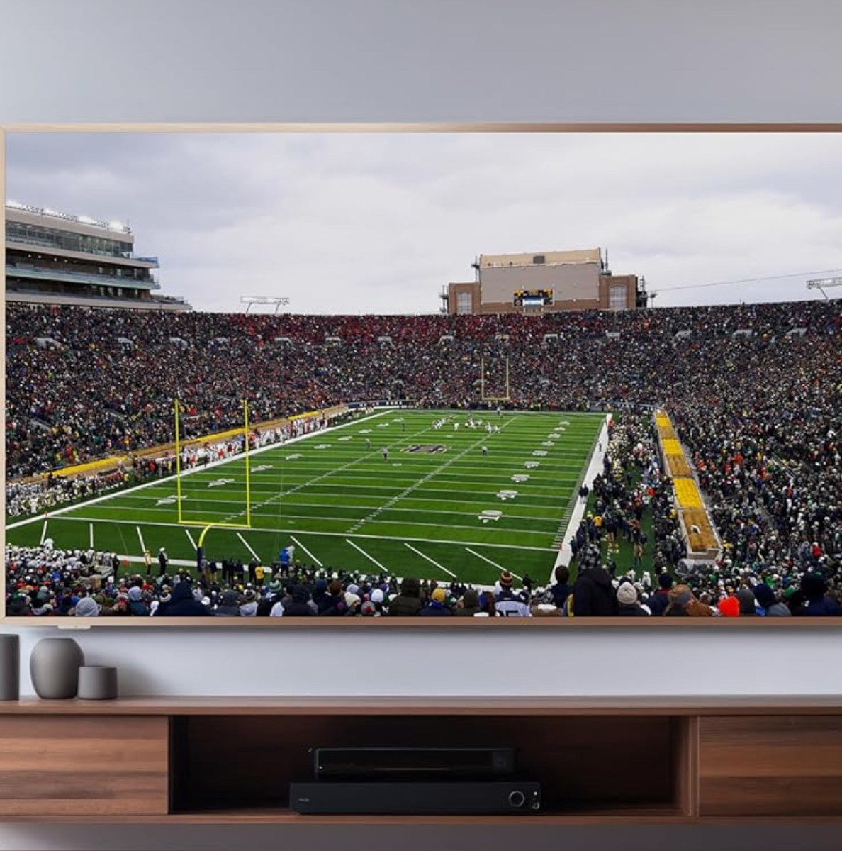 TCL's A300W 4K TV mounted onto a wall above an entertainment center.