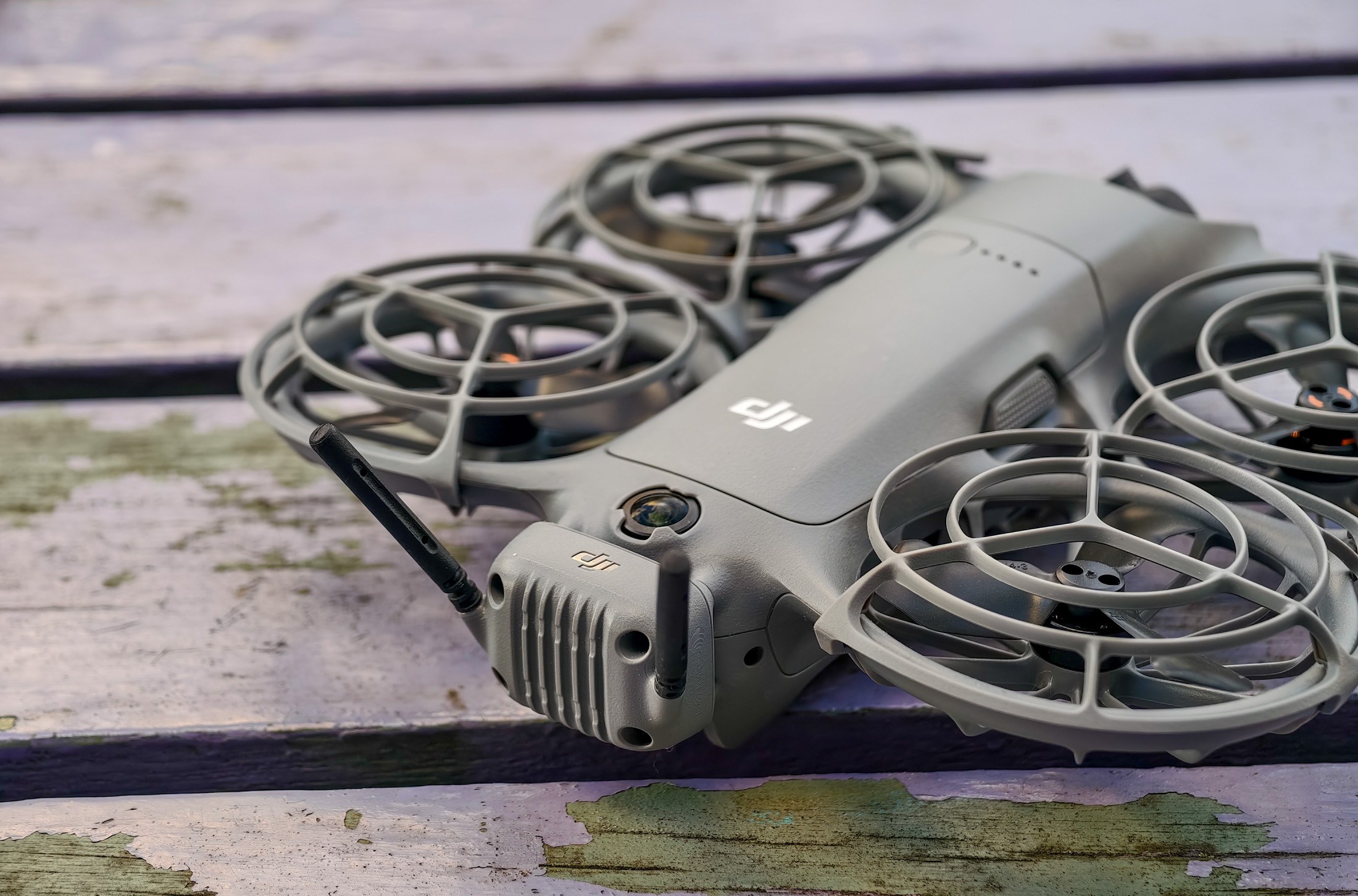 Photo of DJI Neo 2 sitting on a purple table, showing the transceiver