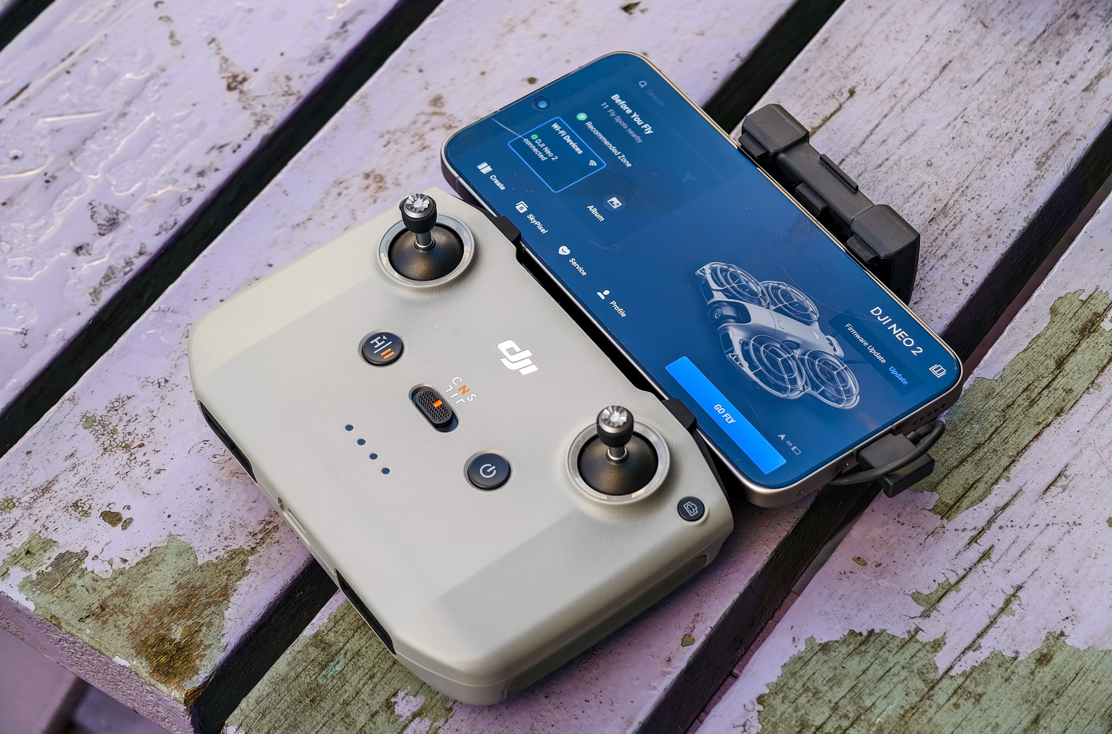 Photo of DJI Neo 2 controller sitting on a purple table with a phone attached