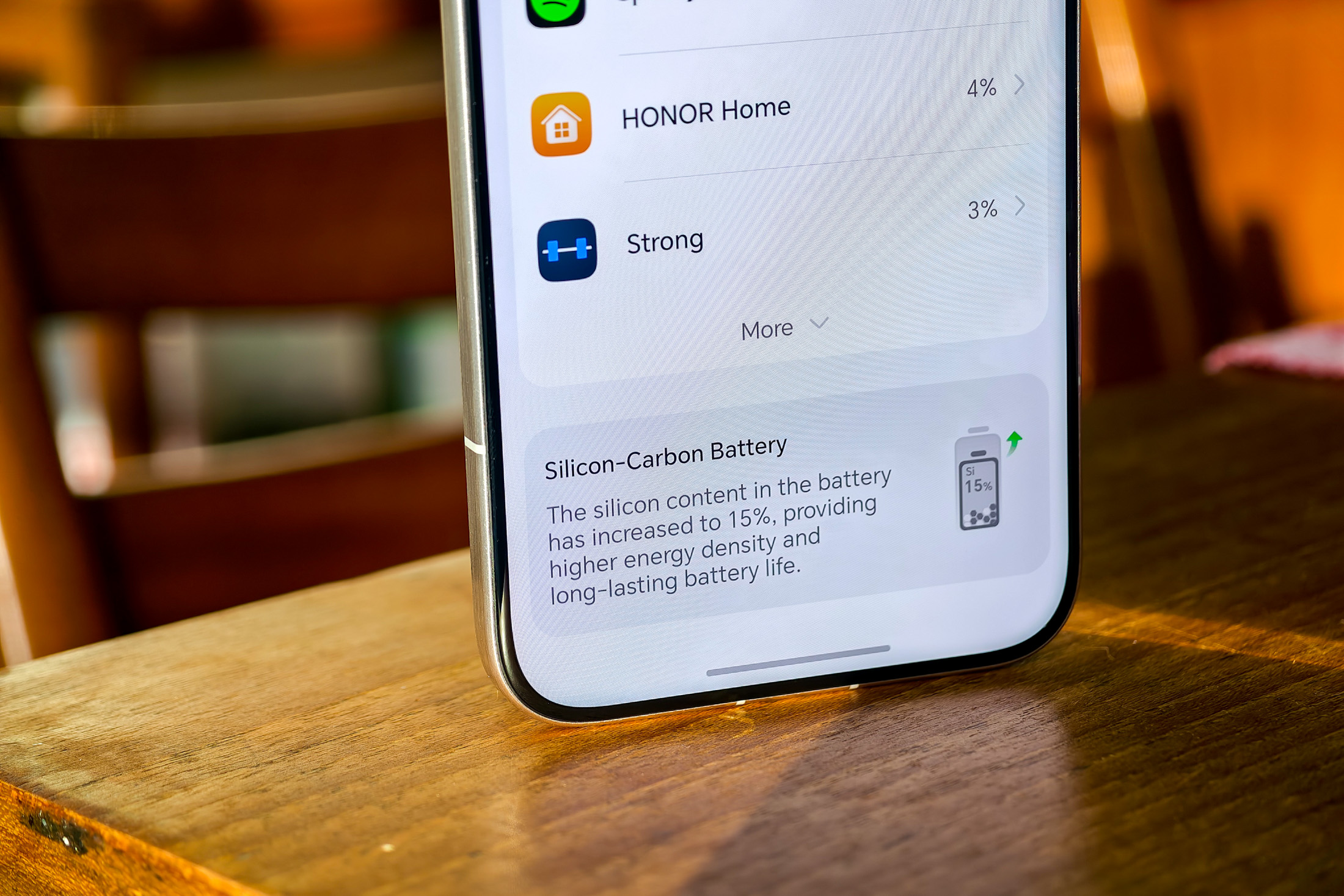 Photo of Honor Magic 8 Pro on a wooden table showing details of the silicon-carbon battery