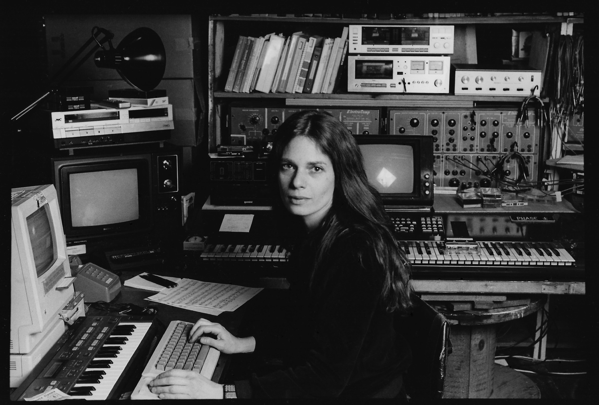 Laurie Spiegel in 1990 in front of her Mac and a large collection of synths and other audio gear.