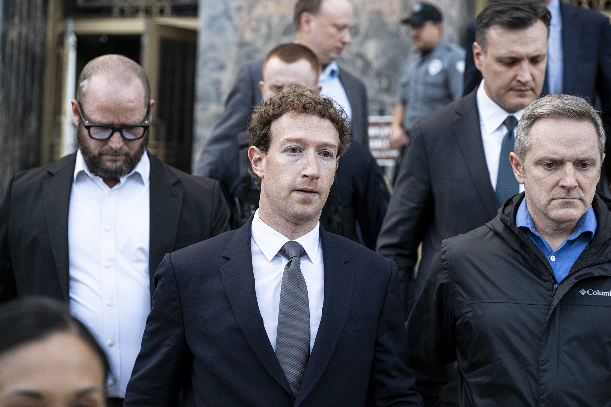 Mark Zuckerberg leaving courthouse surrounded by his legal team.