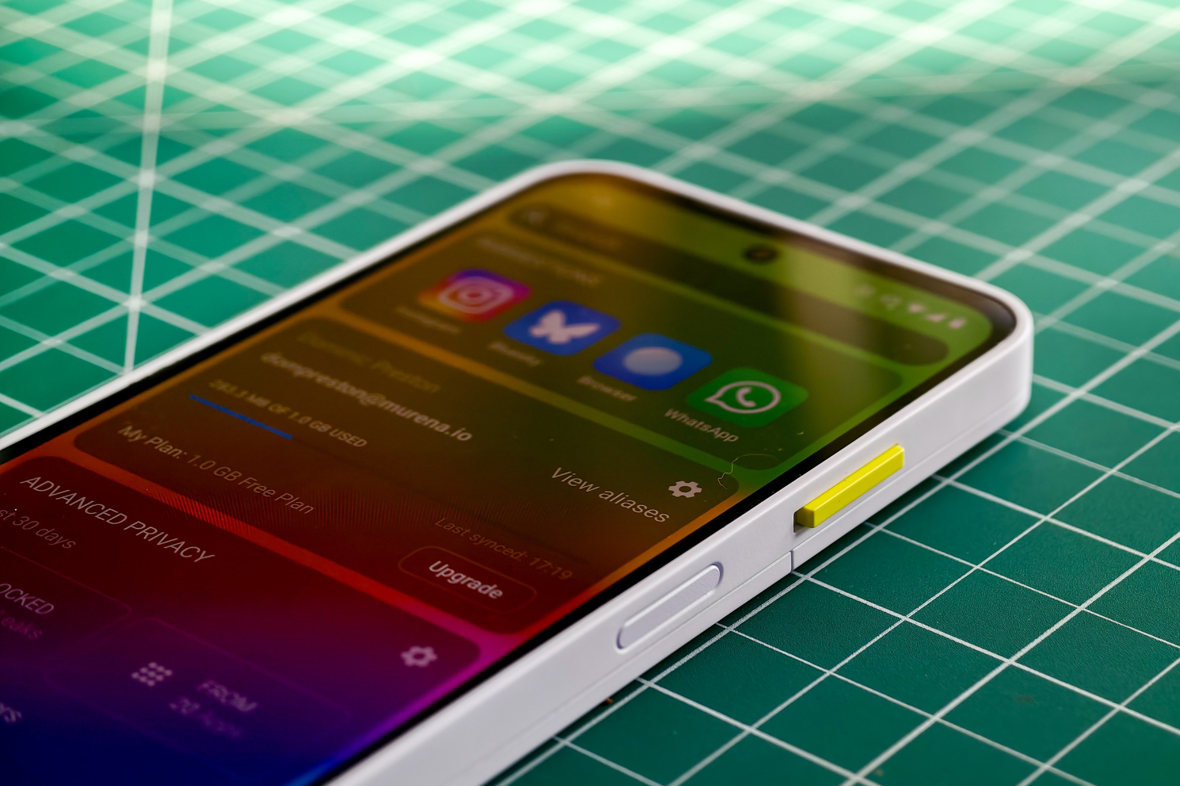 Photo of the Fairphone 6 lying on a green cutting mat with a closeup on the side key