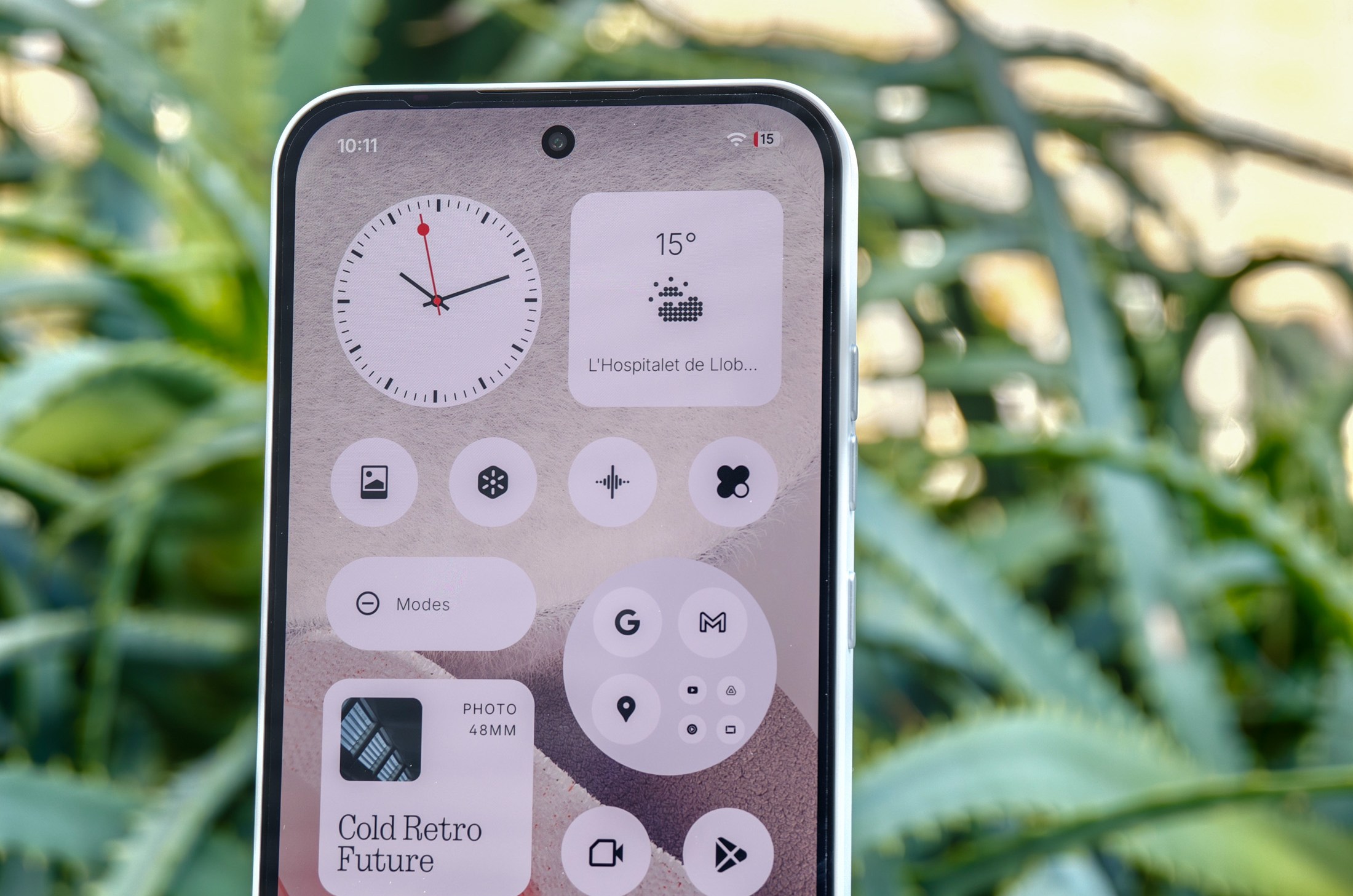 Photo of screen of Nothing Phone 4A in front of plants
