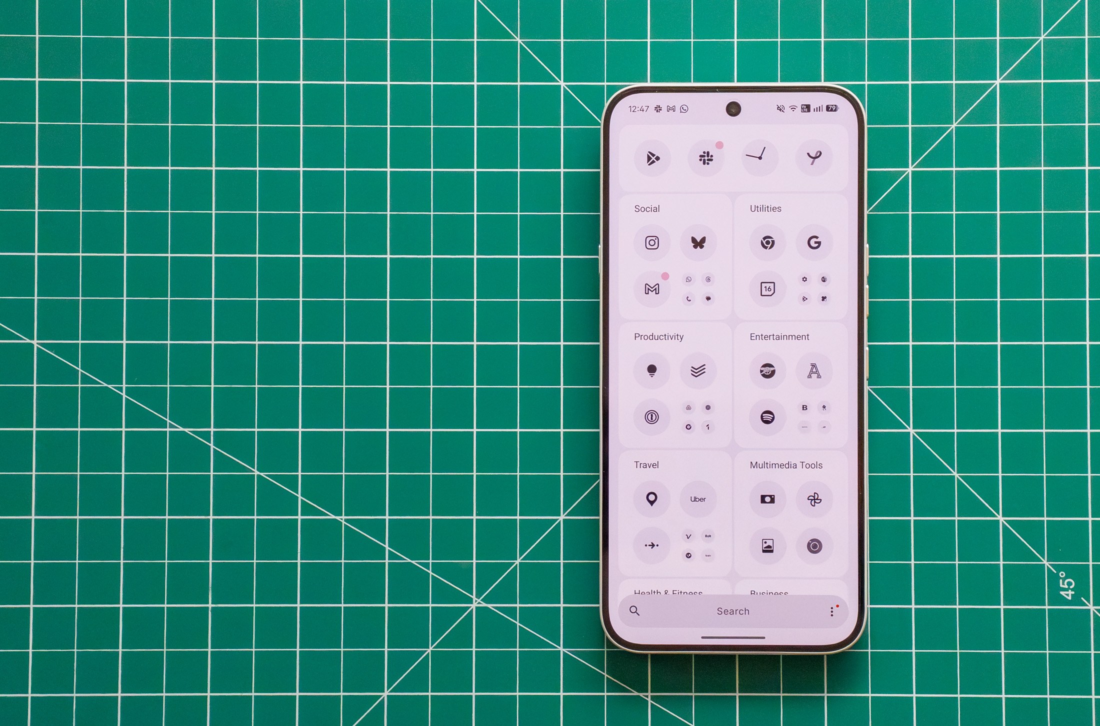 Photo of Nothing Phone 4A Pro on a green cutting mat showing the monochrome app drawer