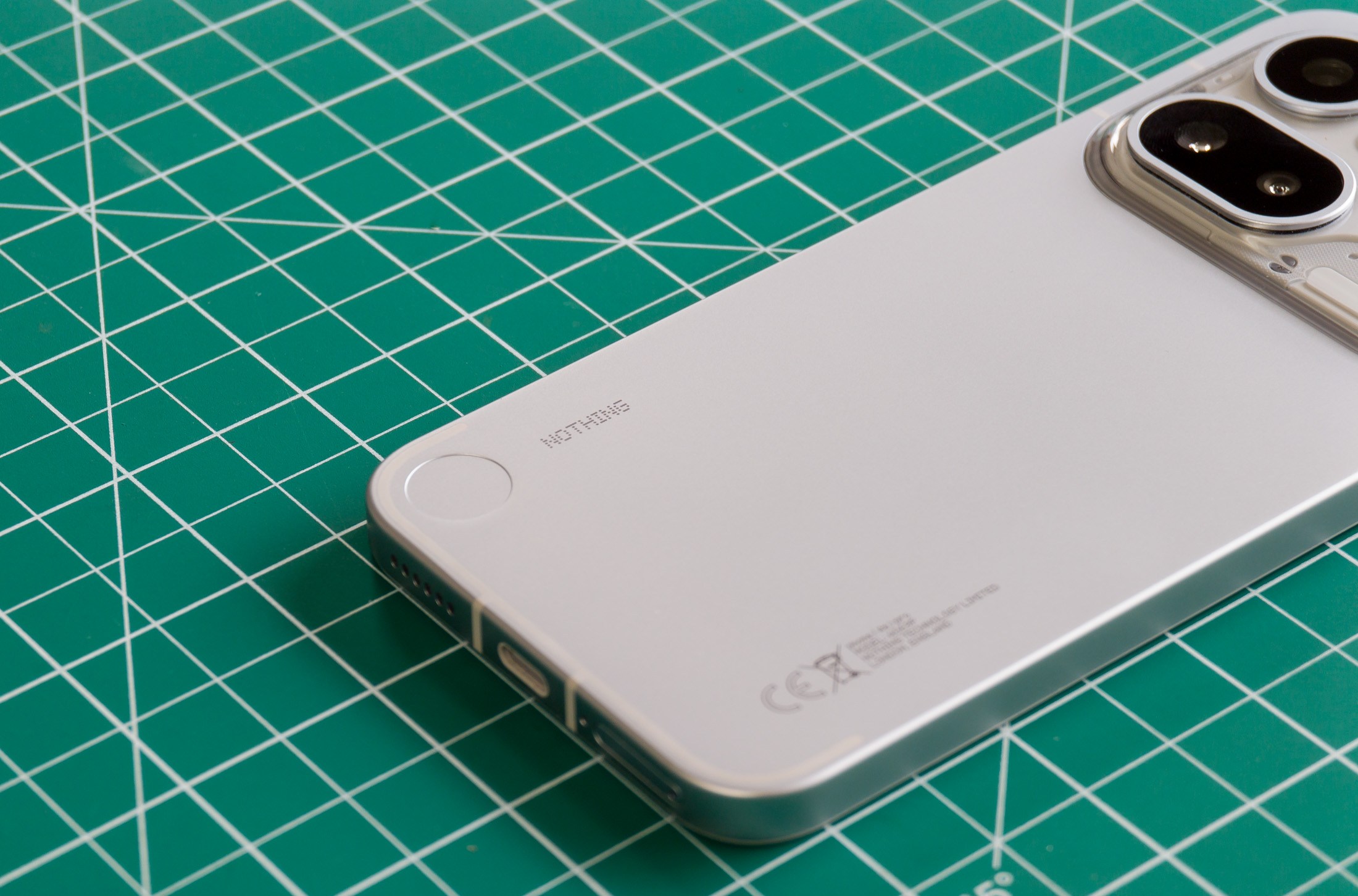 Photo of Nothing Phone 4A Pro on a green cutting mat showing the Nothing logo