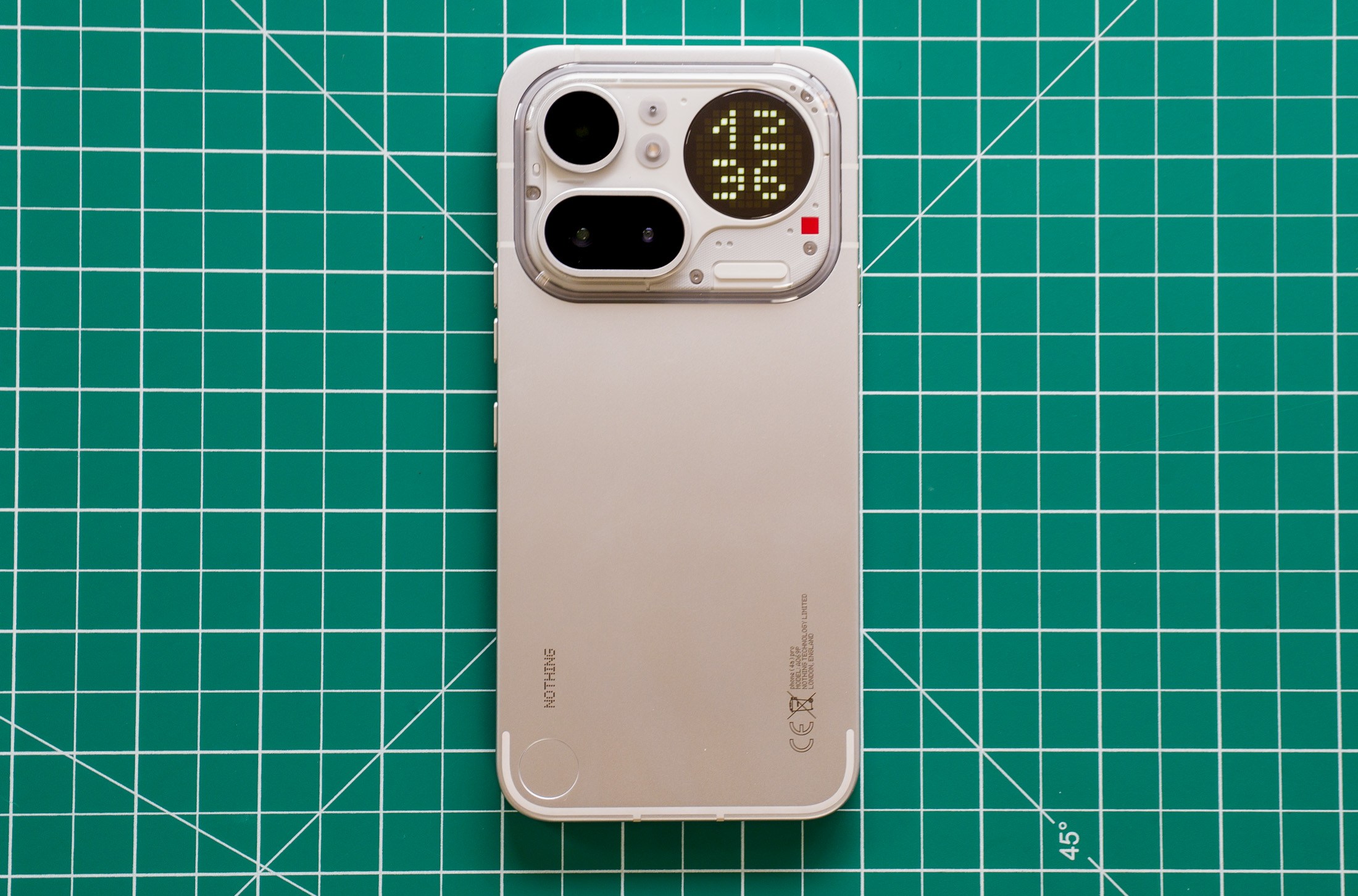 Photo of Nothing Phone 4A Pro on a green cutting mat with the time on the Glyph Matrix