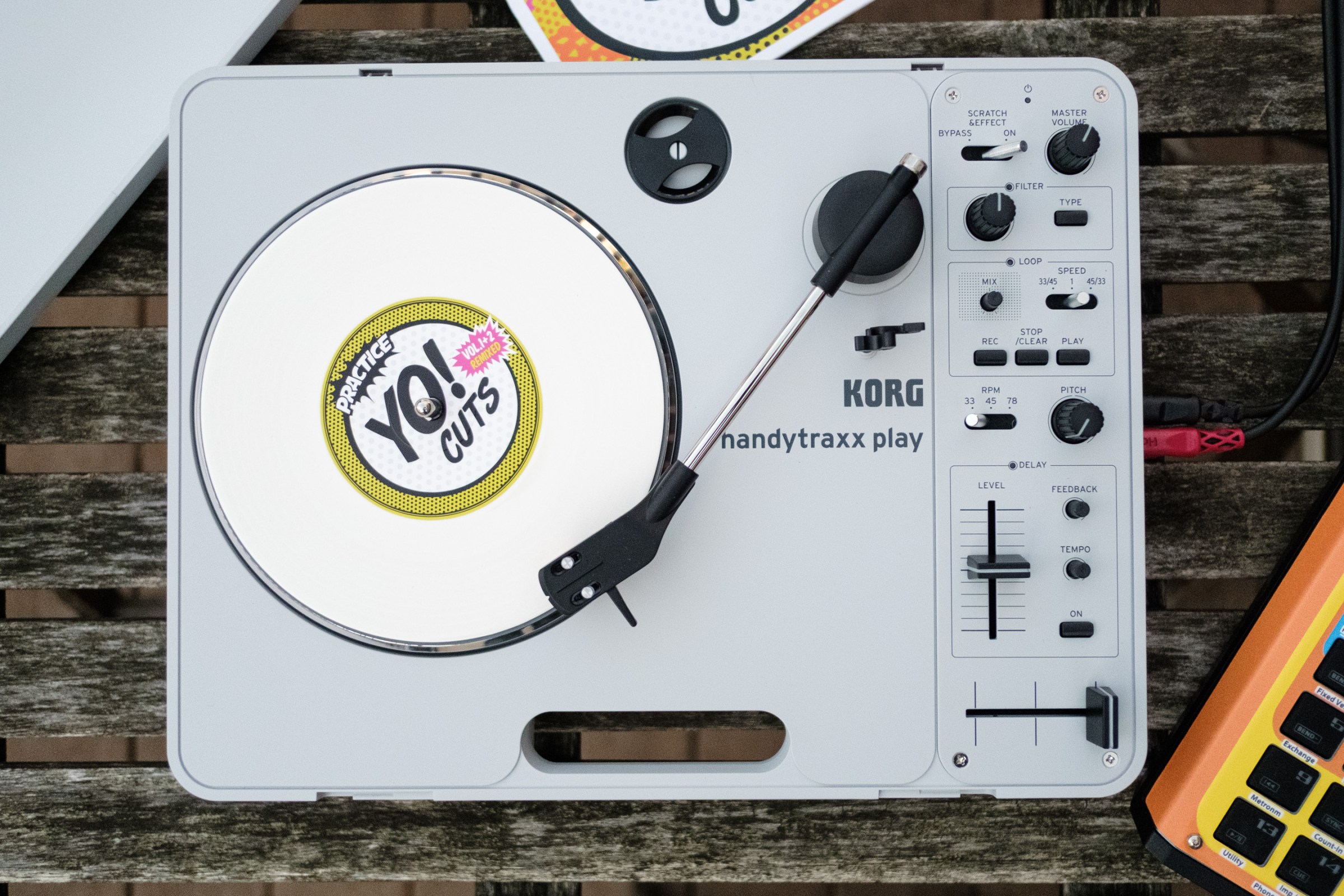 The Korg Handytraxx Play portable turntable on a beat up piece of deck furniture.