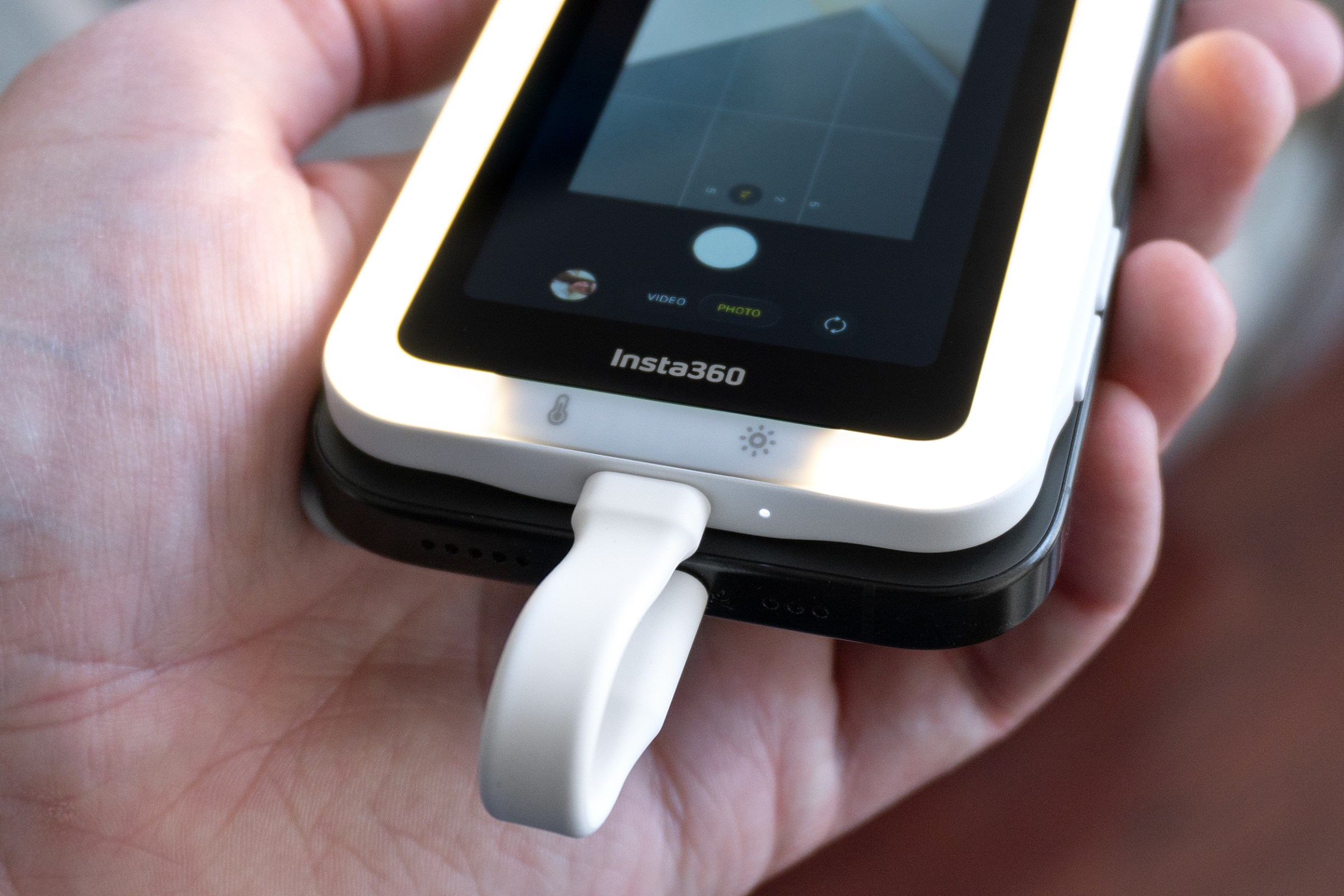 A close-up of two buttons on the bottom of the Insta360 Snap screen below its display.