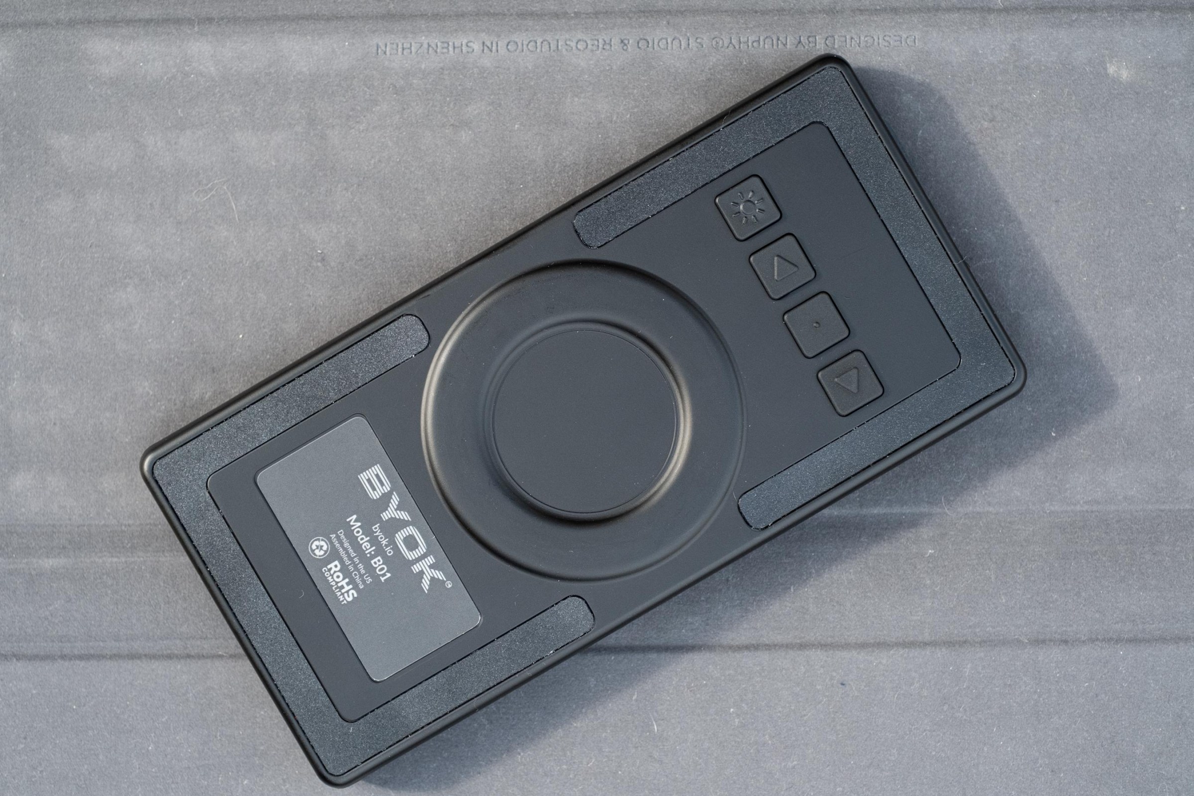 The back of the BYOK showing the company logo, a button for toggling the backlight, and buttons for navigating the interface when a keyboard isn’t connected.