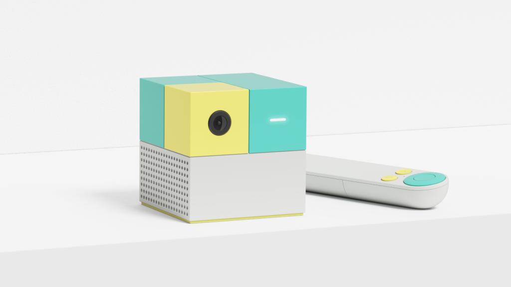 A cube-shaped Nex Playground console on a white background, with its remote control next to it.