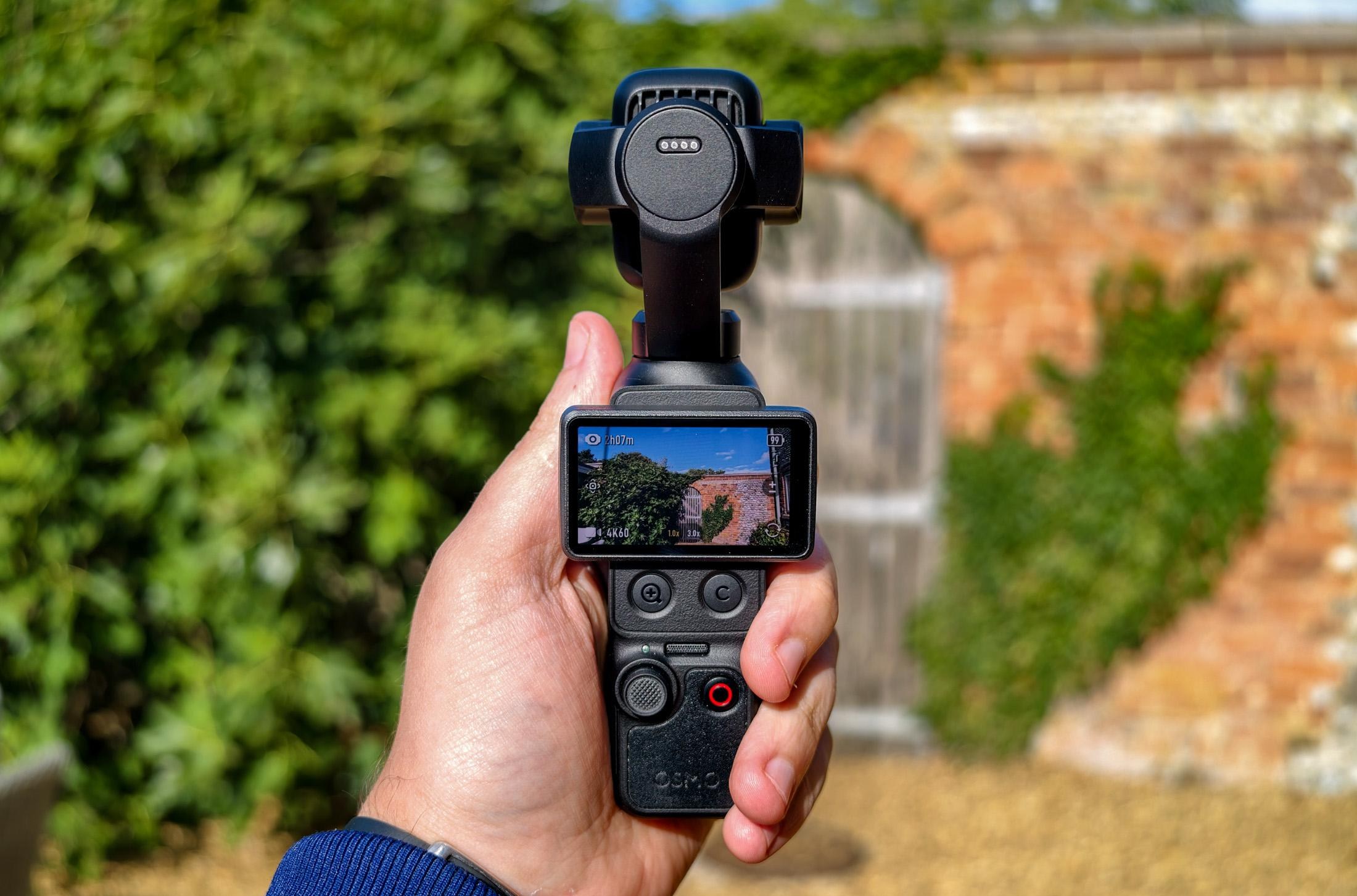 Photo of DJI Osmo Pocket 4P with a brick wall in the background.