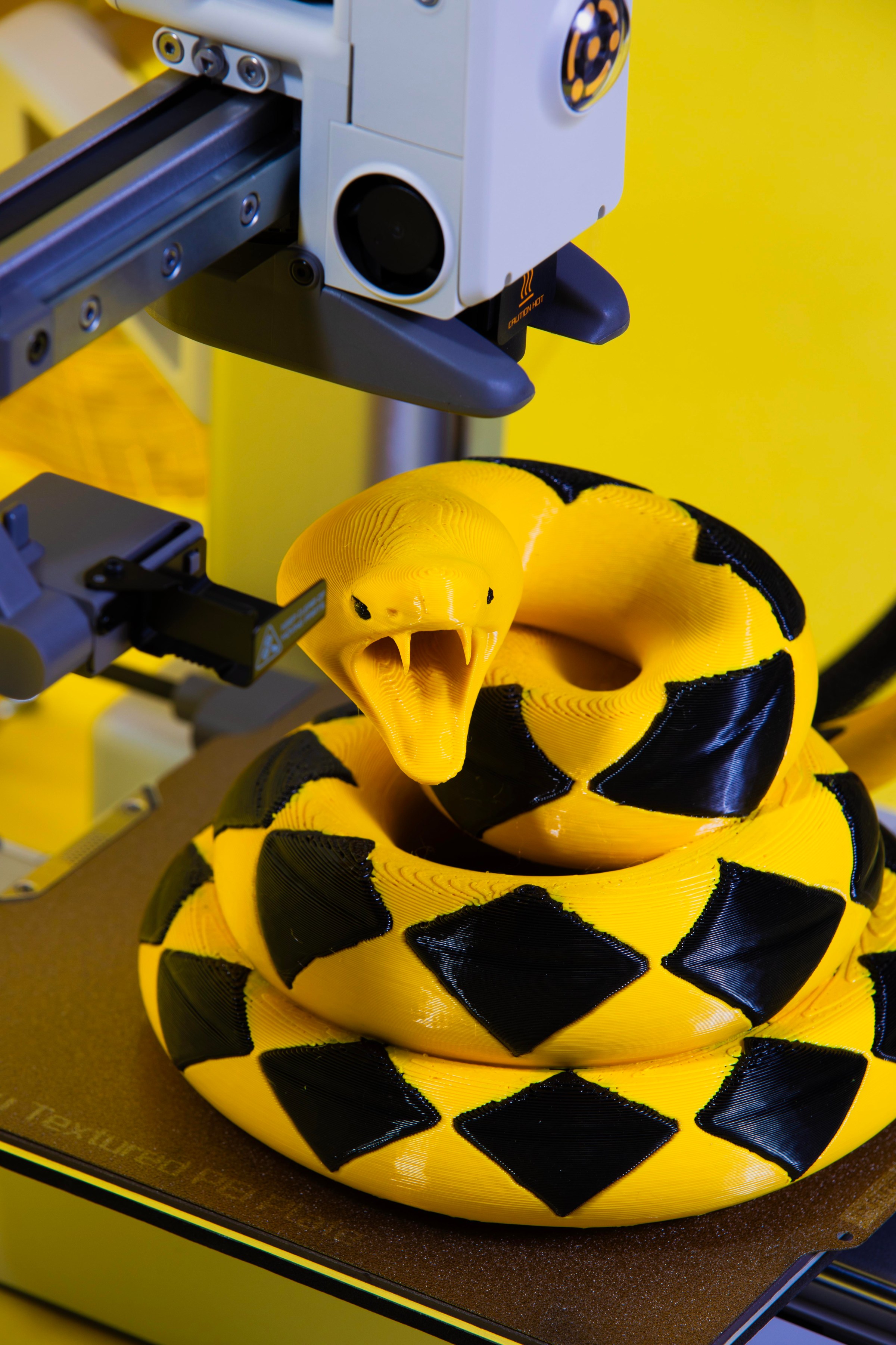 Sculpture of a snake sitting on a 3D print bed.