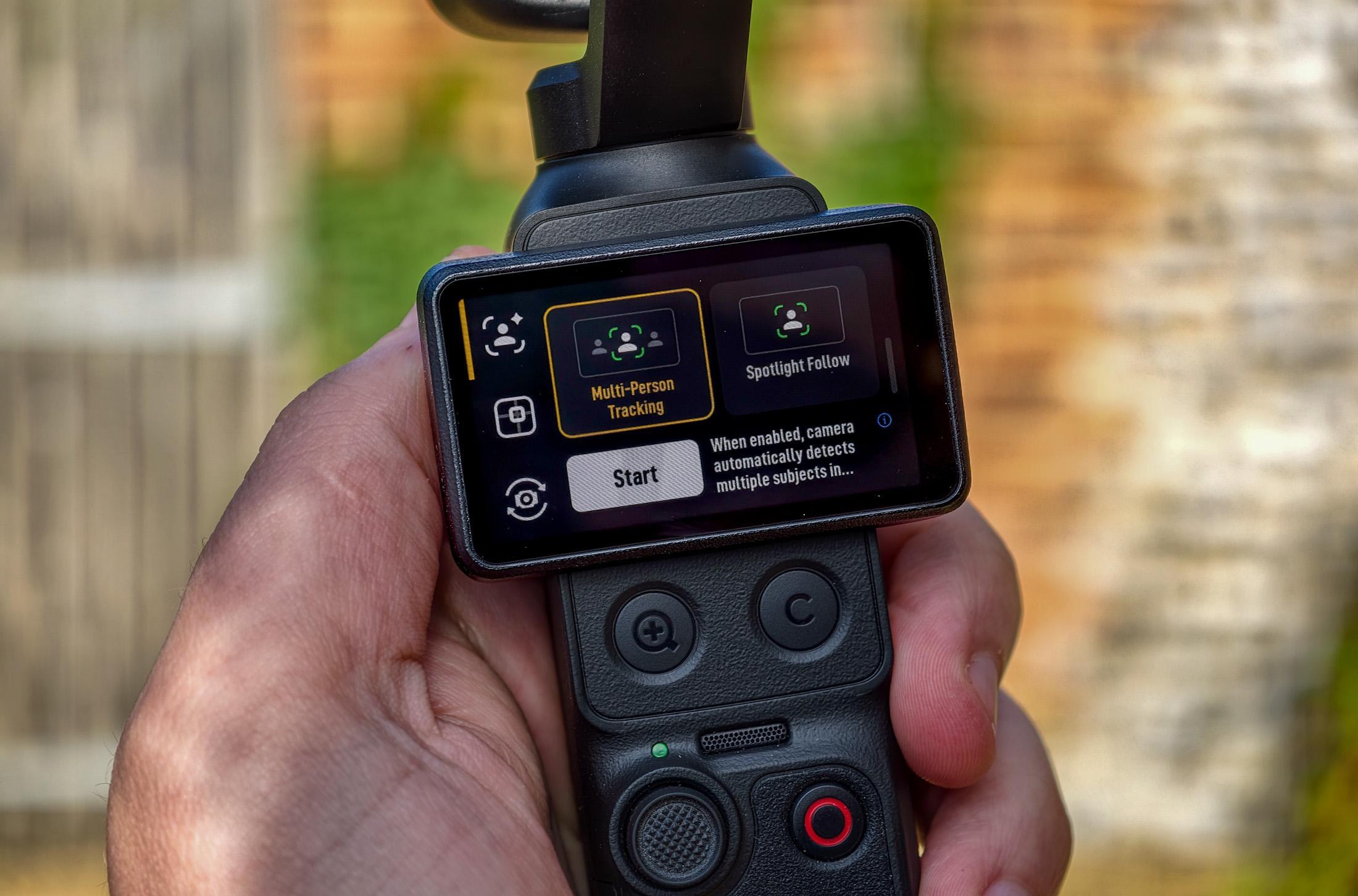 Photo of DJI Osmo Pocket 4P showing the screen with multi-person tracking and spotlight follow options visible.
