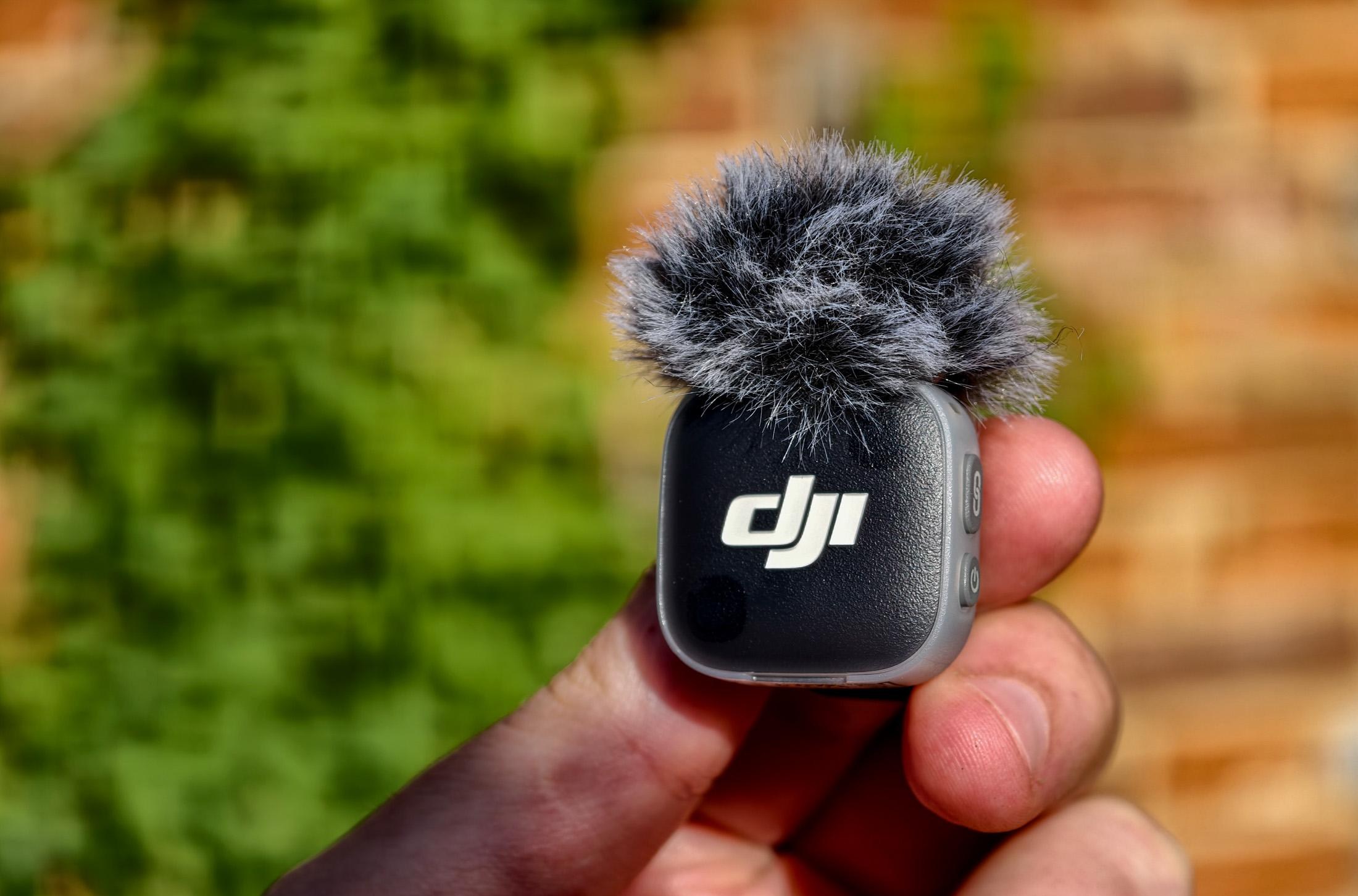 Photo of DJI Mic Mini 2 in front of a brick wall.