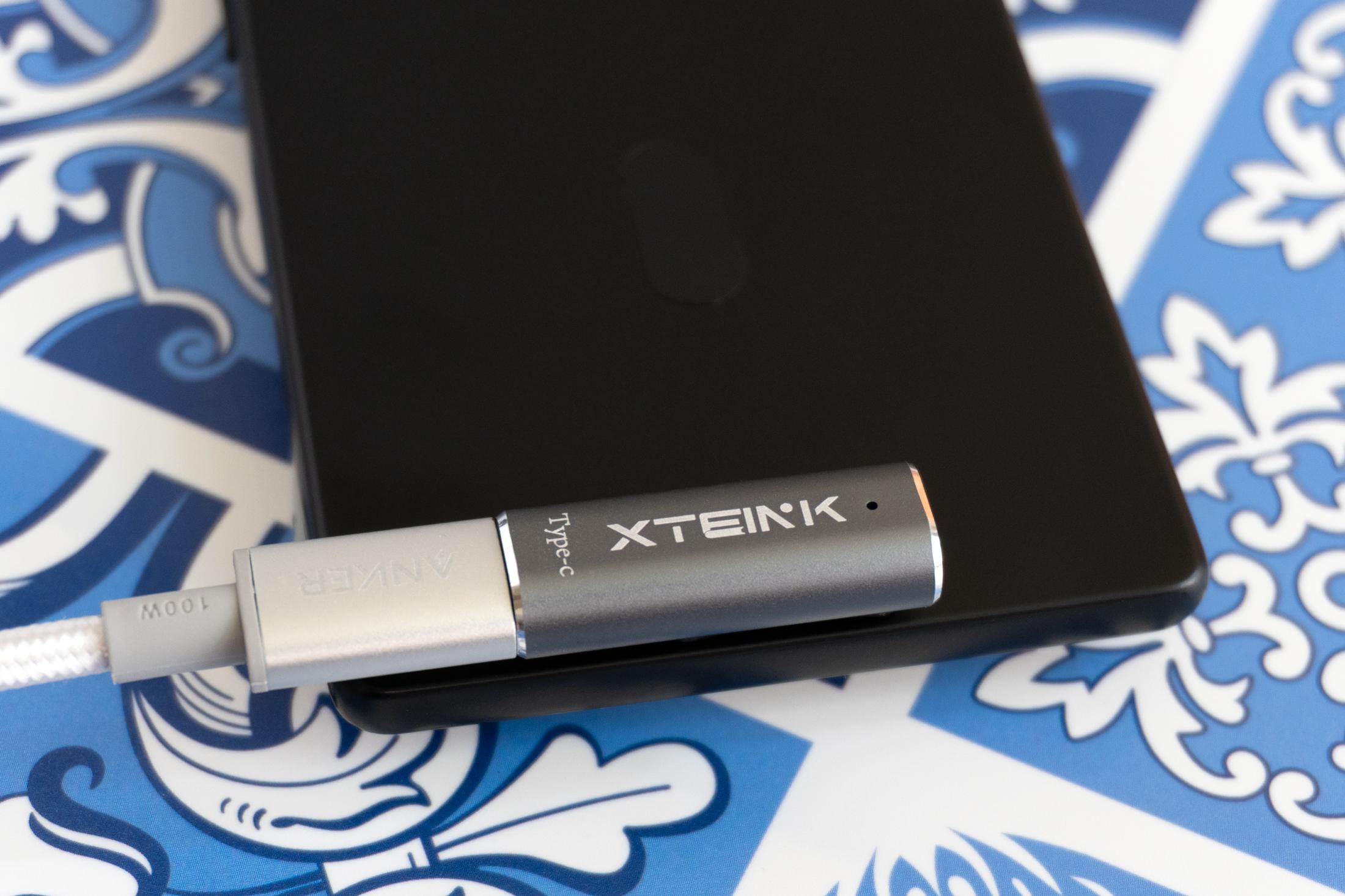 A close-up of a magnetic pogo-pin charger attached to the back of the Xteink X4 Pro.