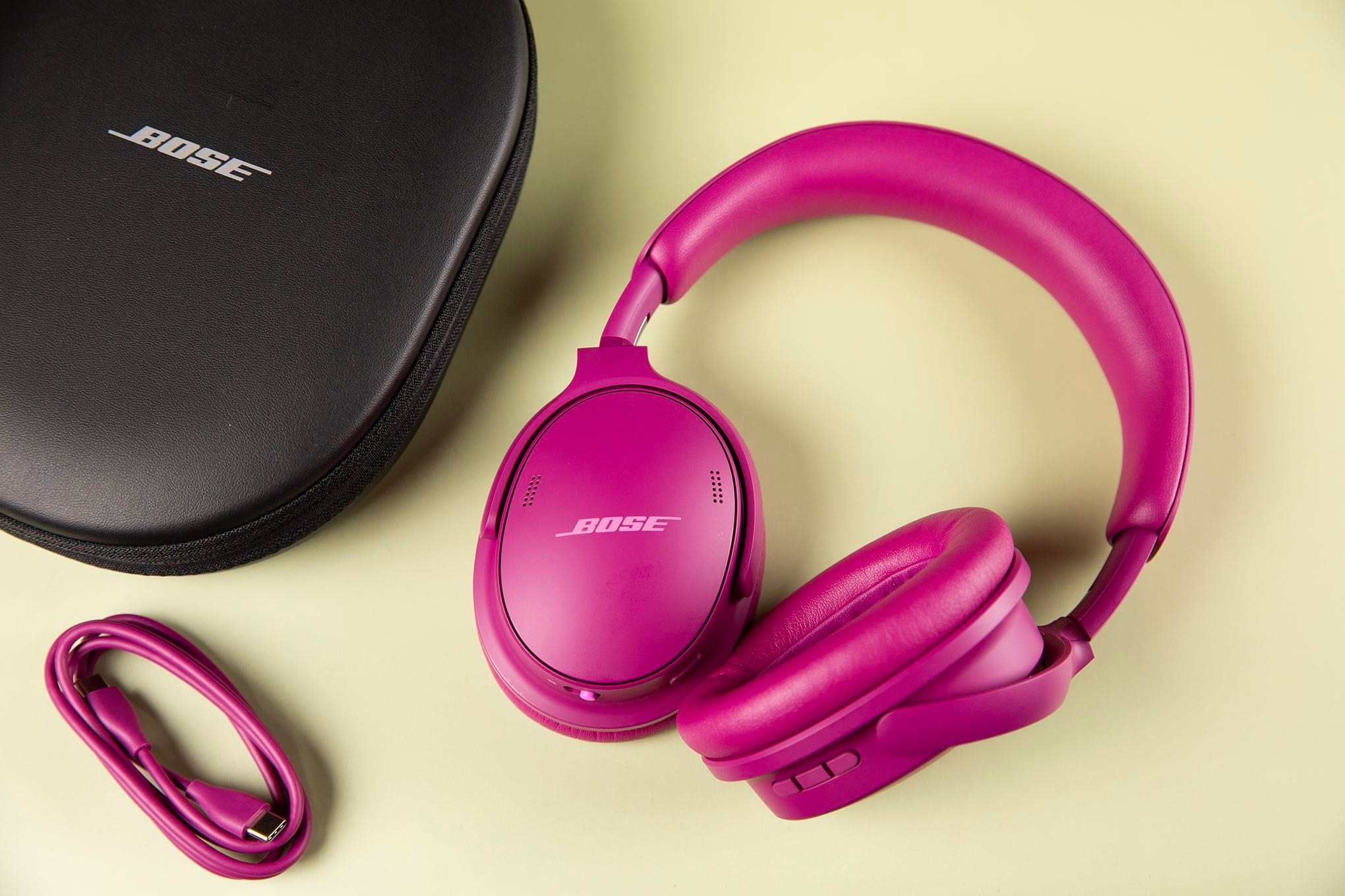 Gen 2 Bose QuietComfort Headphones sitting on a pale yellow surface next to a USB-C charger and black Bose case.