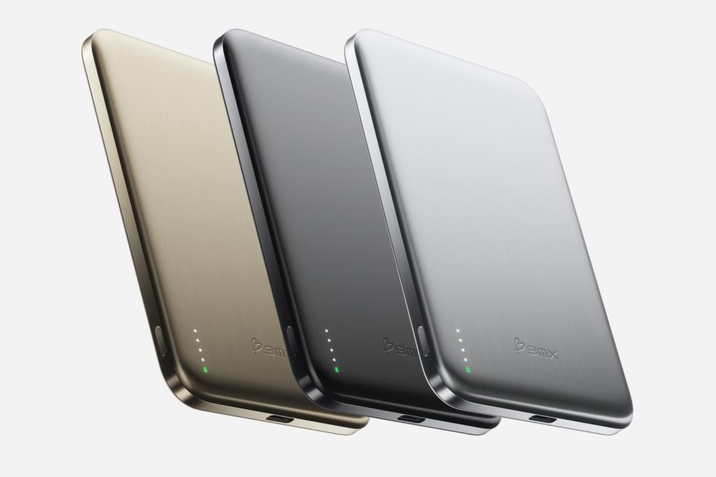Three BMX Solidsafe Air 5K portable chargers – a gold one, a black one and a silver one – on a plain background