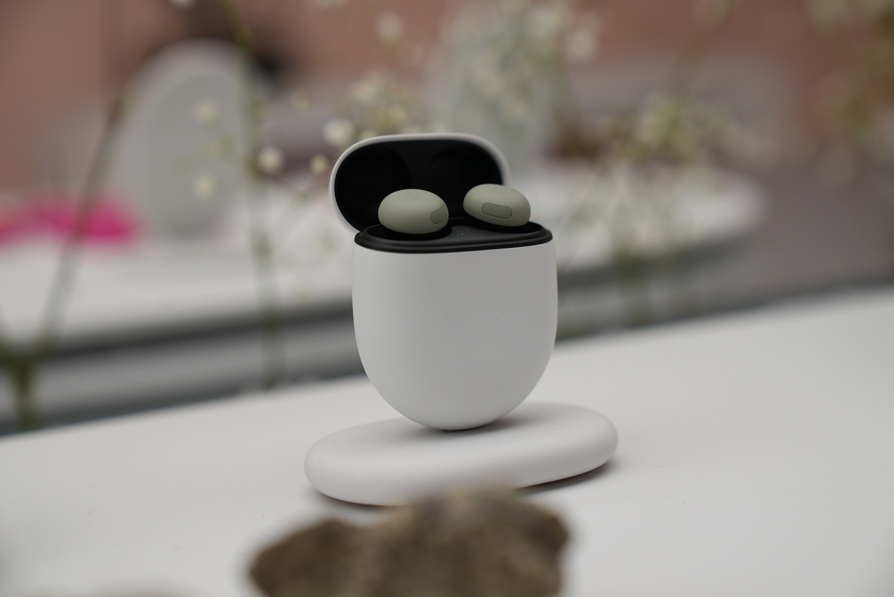 The olive Google Pixel Buds Pro 2 in their open case at the Made by Google 2026 event.