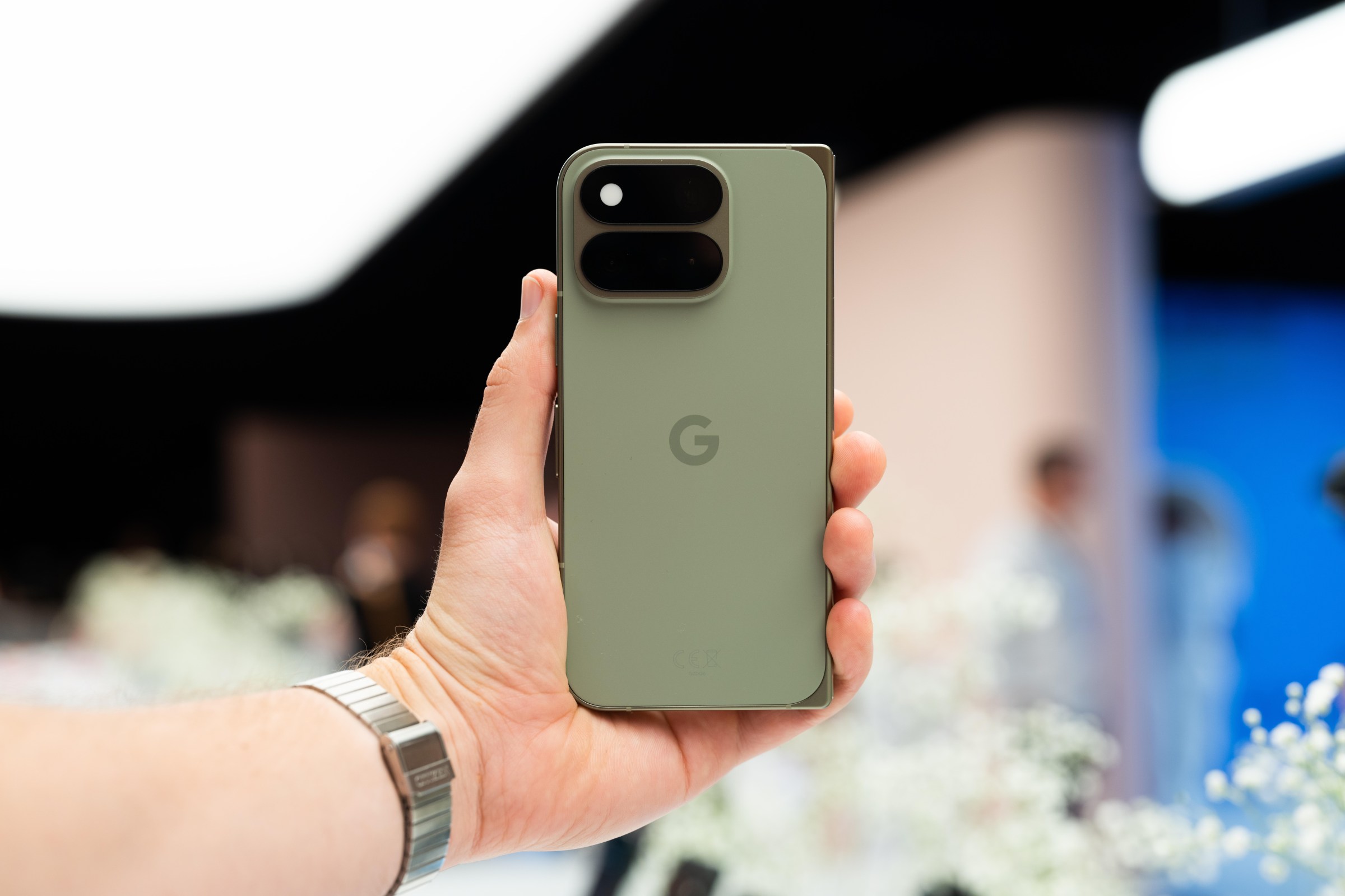 A hand holding the green Pixel 11 Pro Fold