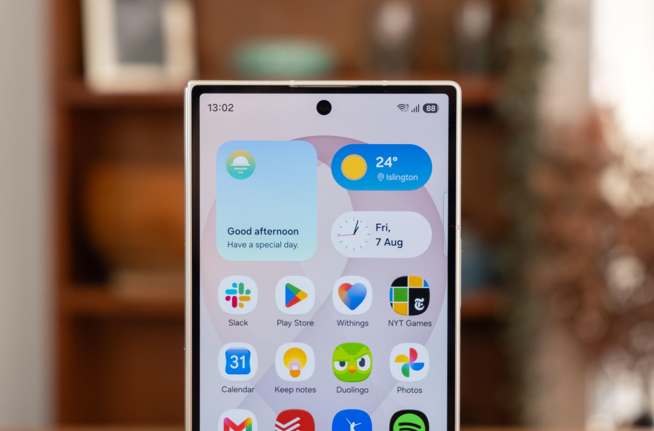 Photo of Samsung Galaxy Z Fold 8 Ultra in front of a bookcase, showing the front display and selfie camera